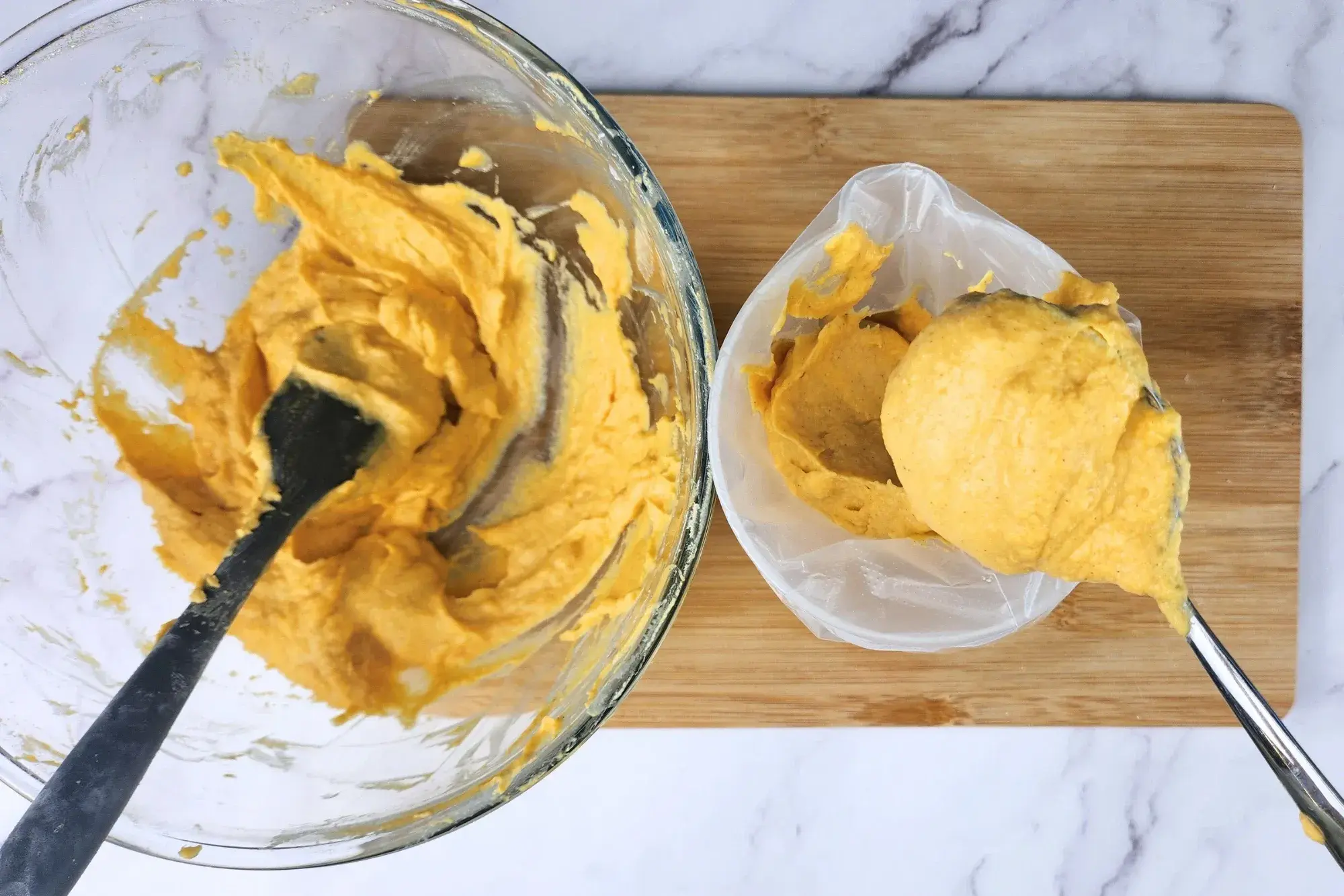 A mixing bowl with pumpkin puree and a spoon full with pumpkin puree.