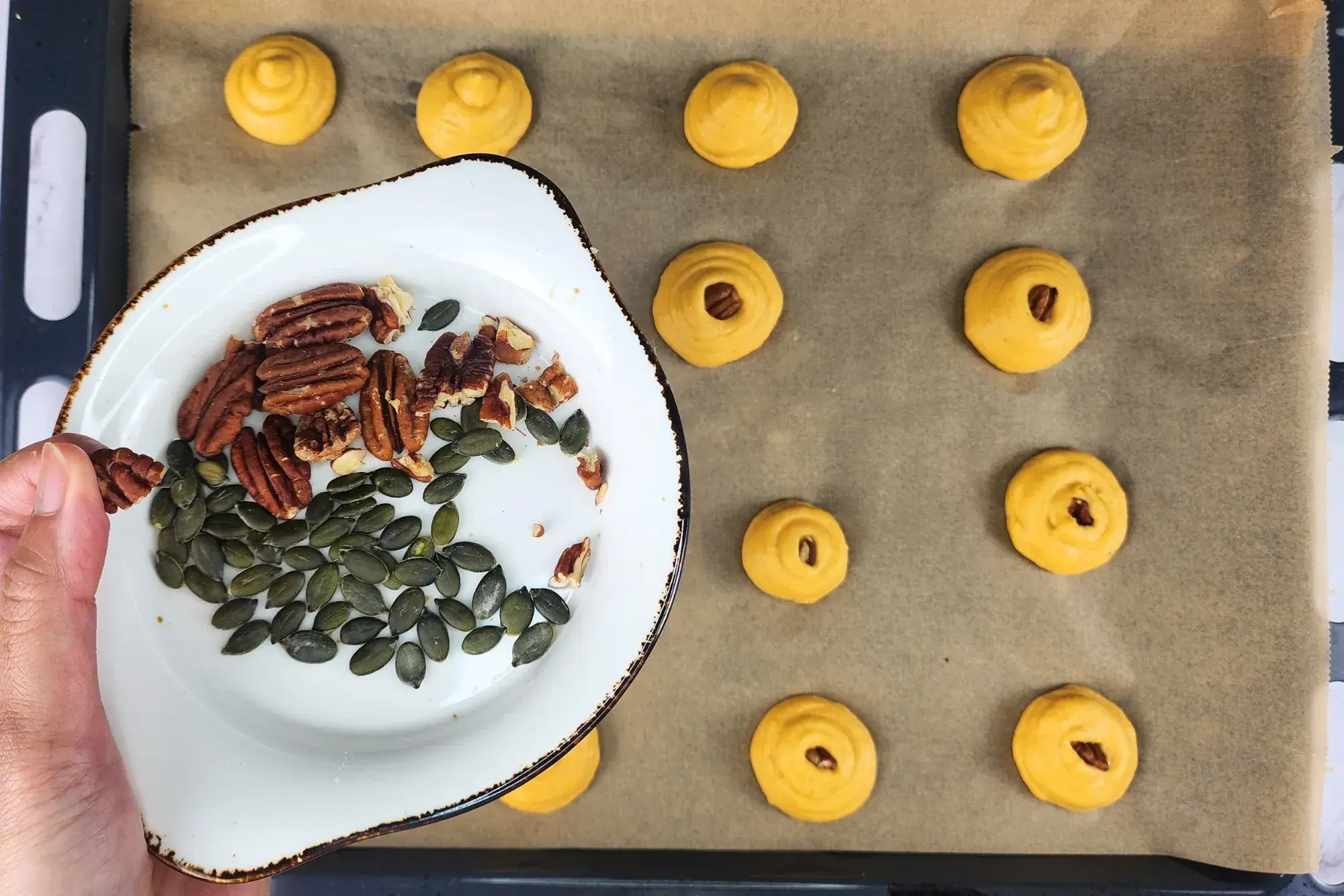 A plate of nuts above a baking tray.