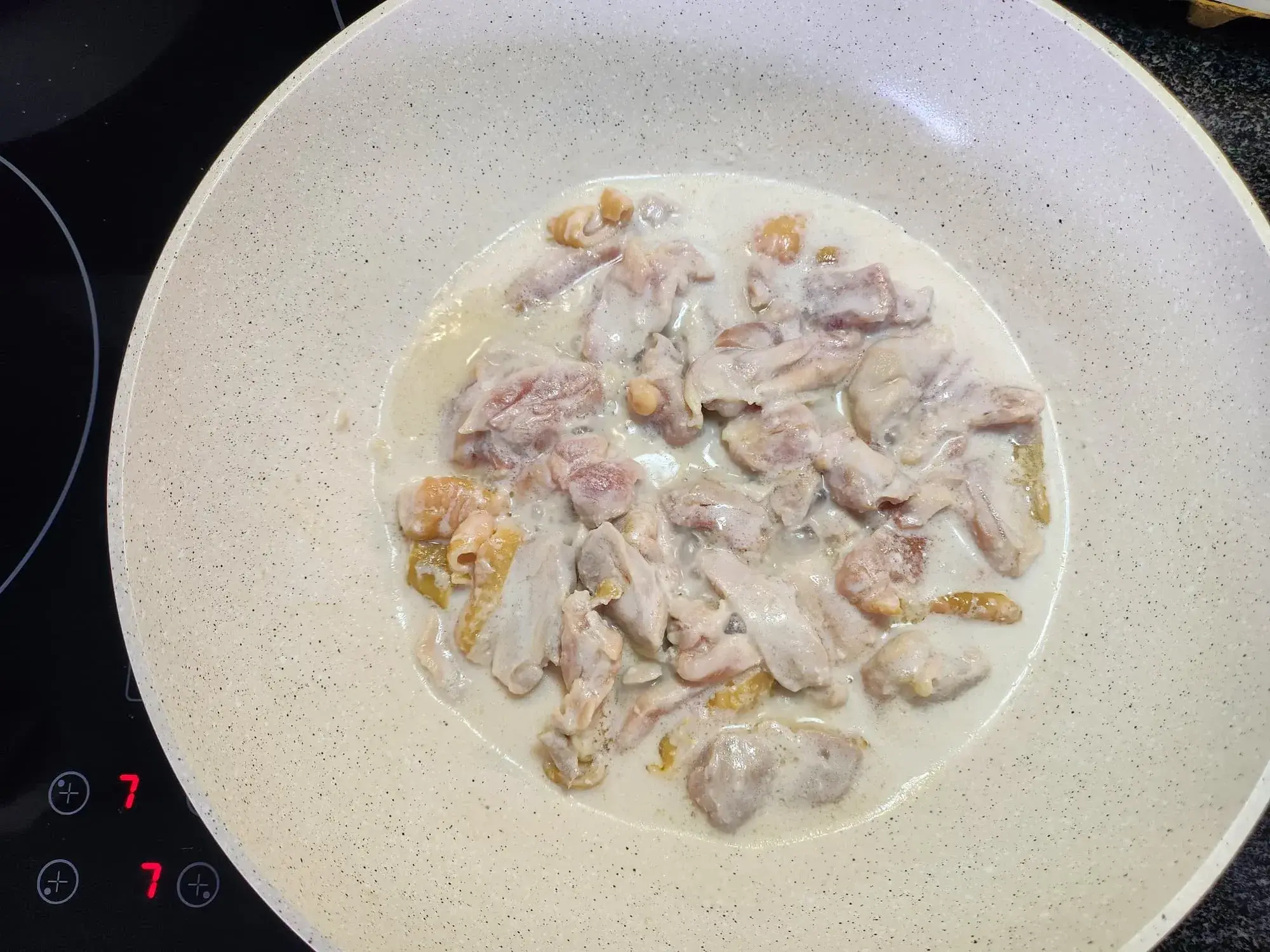 In a second pan, heat a portion of the coconut milk with the sliced chicken breast and cook until it's no longer pink.