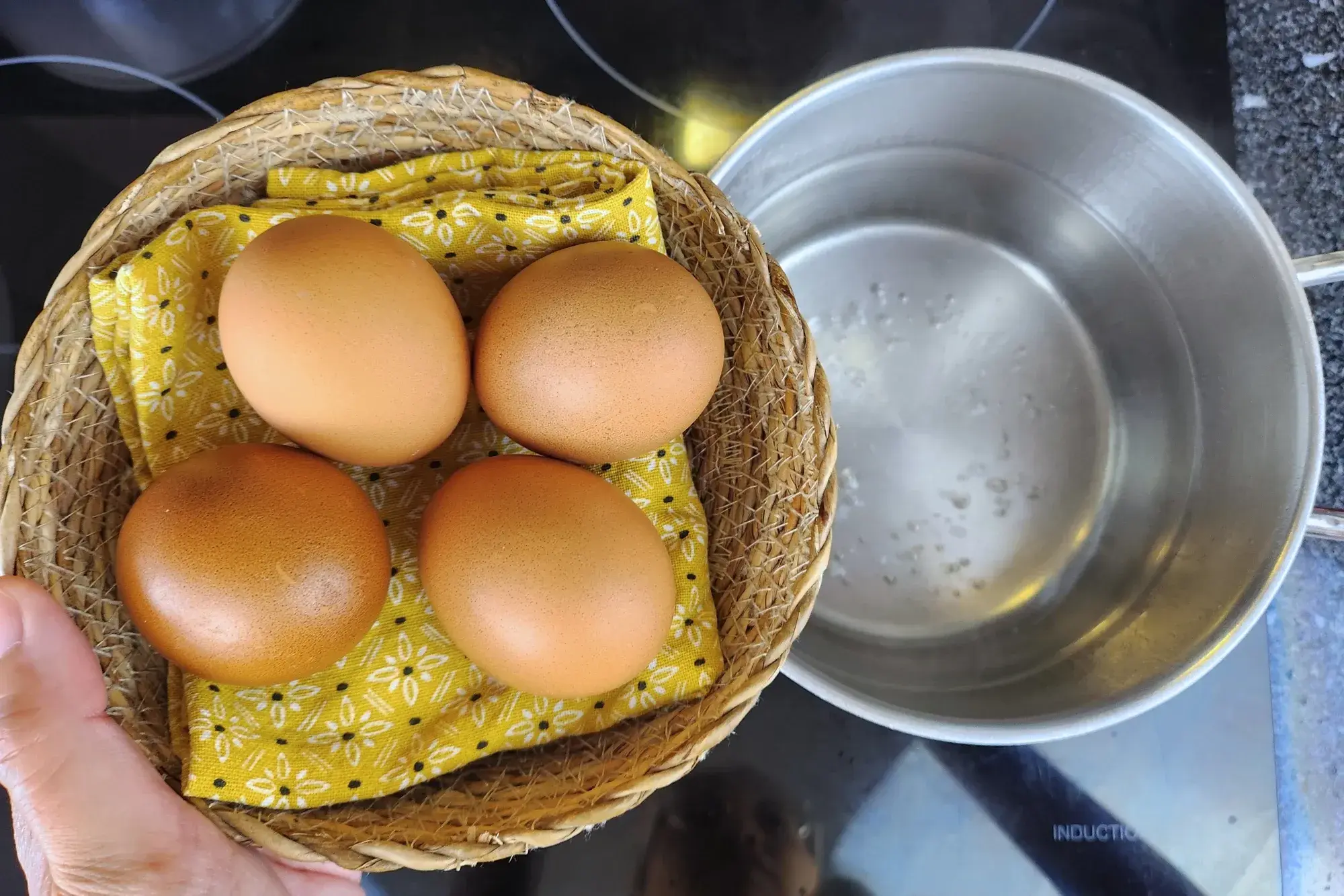 4 eggs in basket above a pot with boiling water
