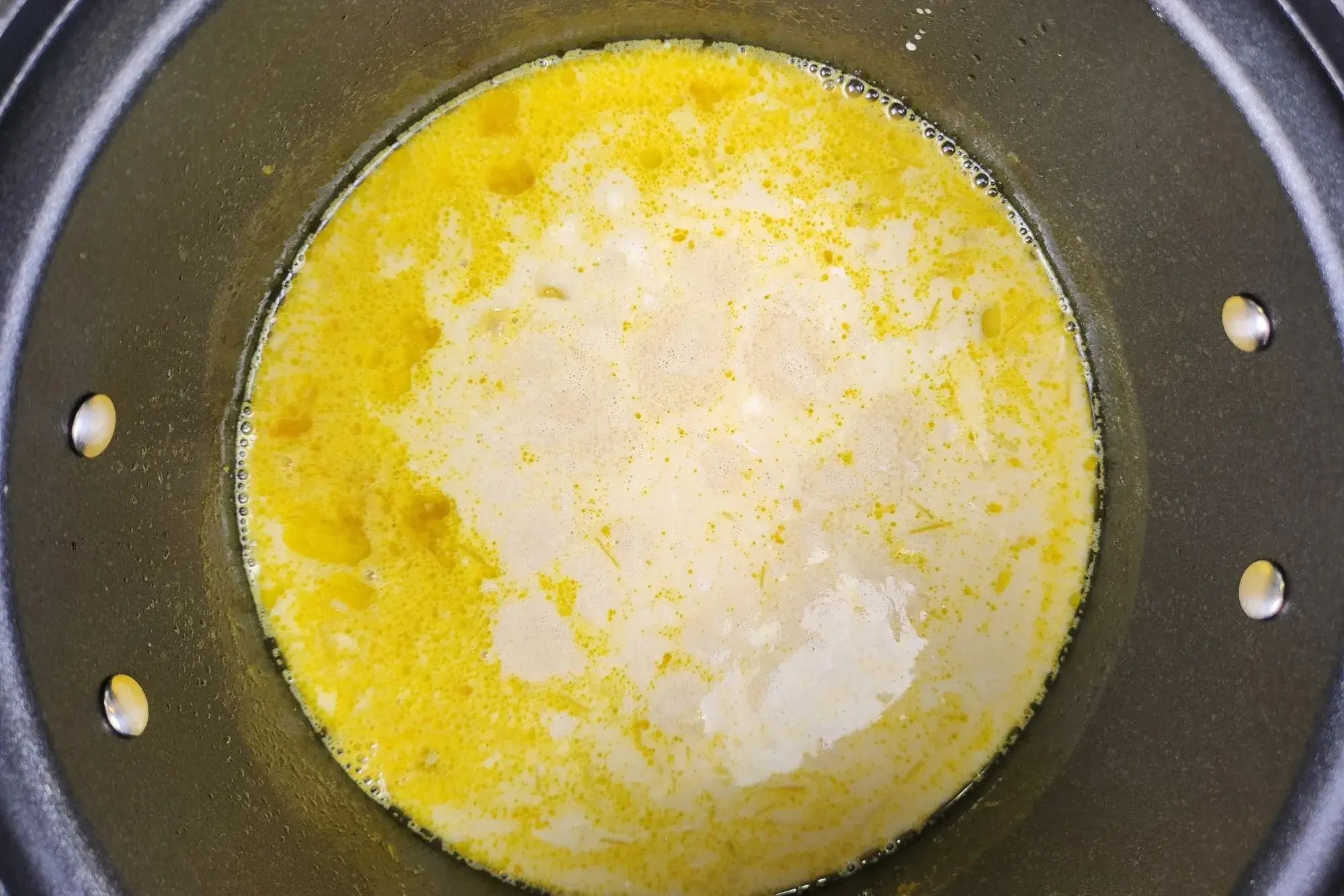 A boiling yellow soup in a pot