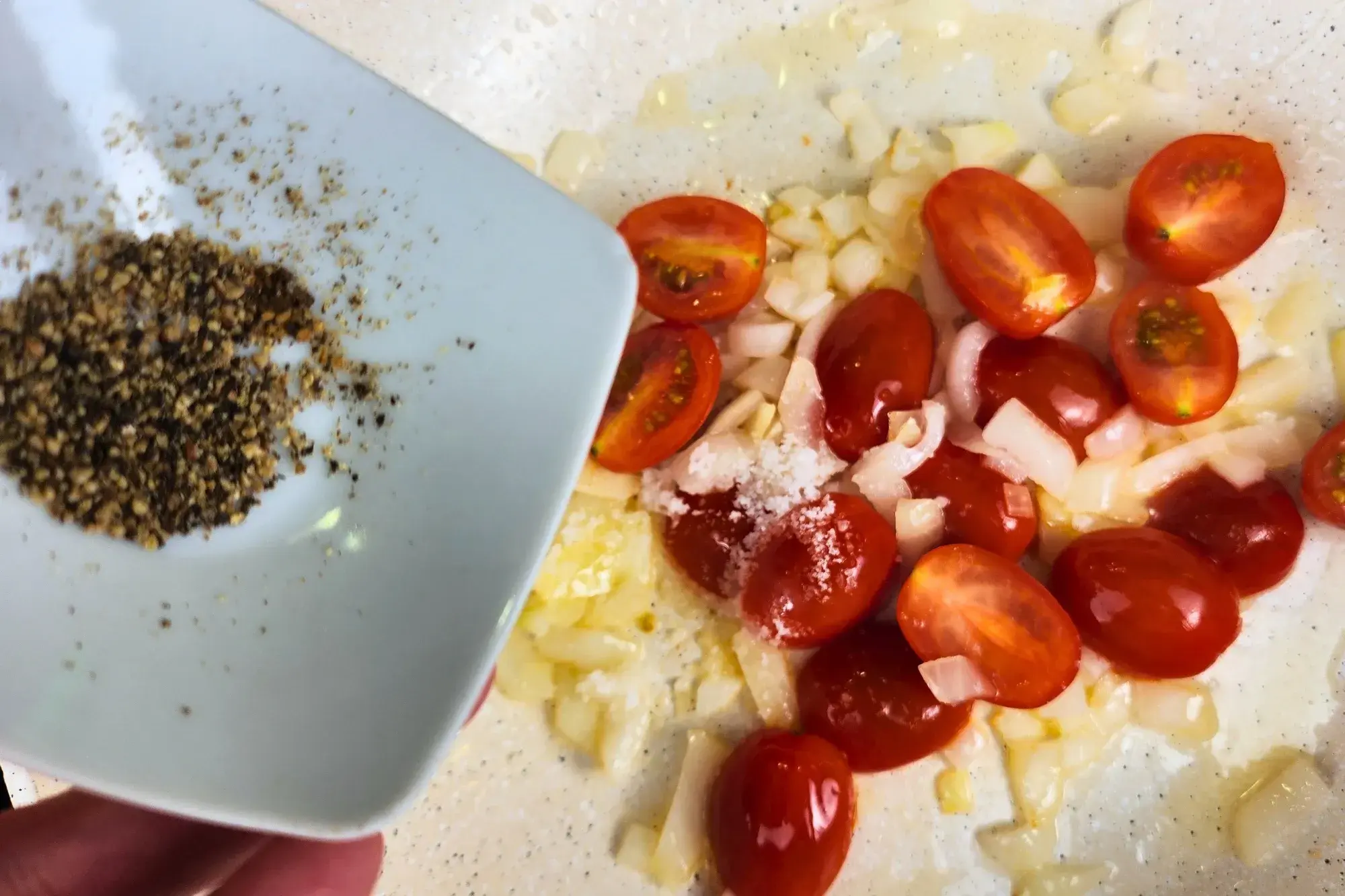 A bowl of cooking oil is above a pan