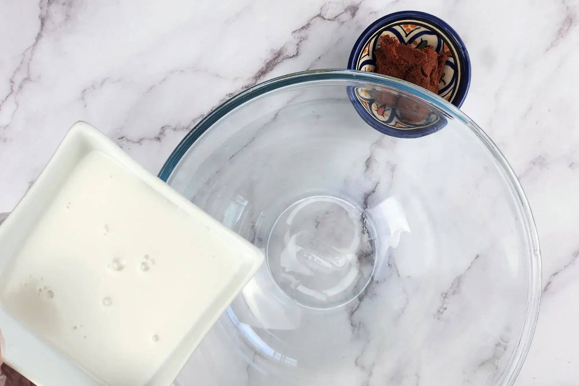 A bowl of coconut milk above the mixing bowl