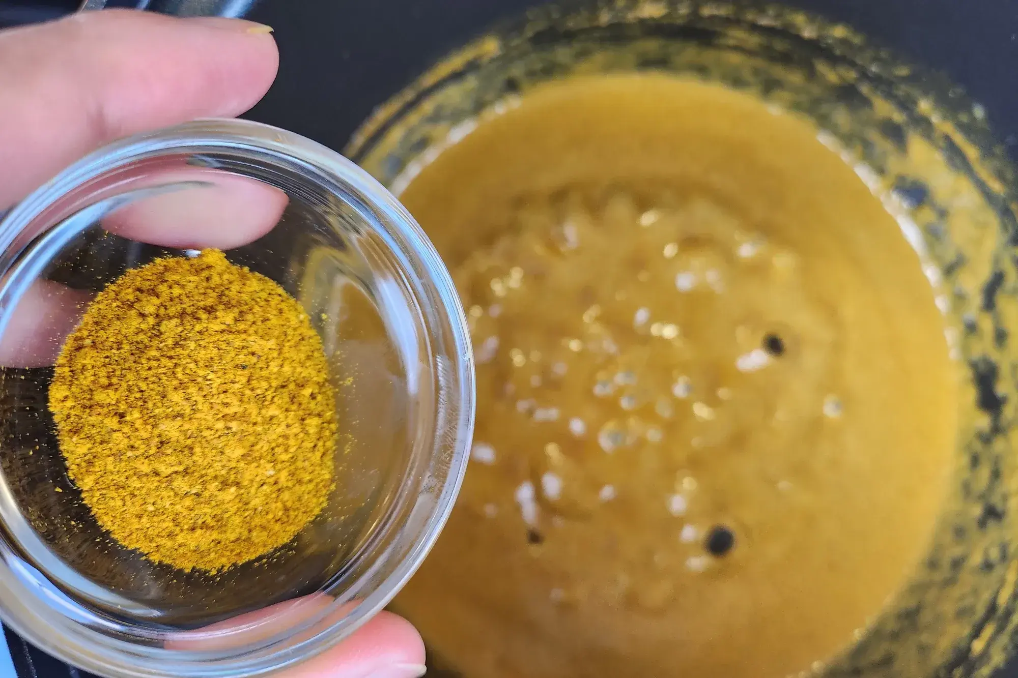 A bowl of curry powder above the curry pot.