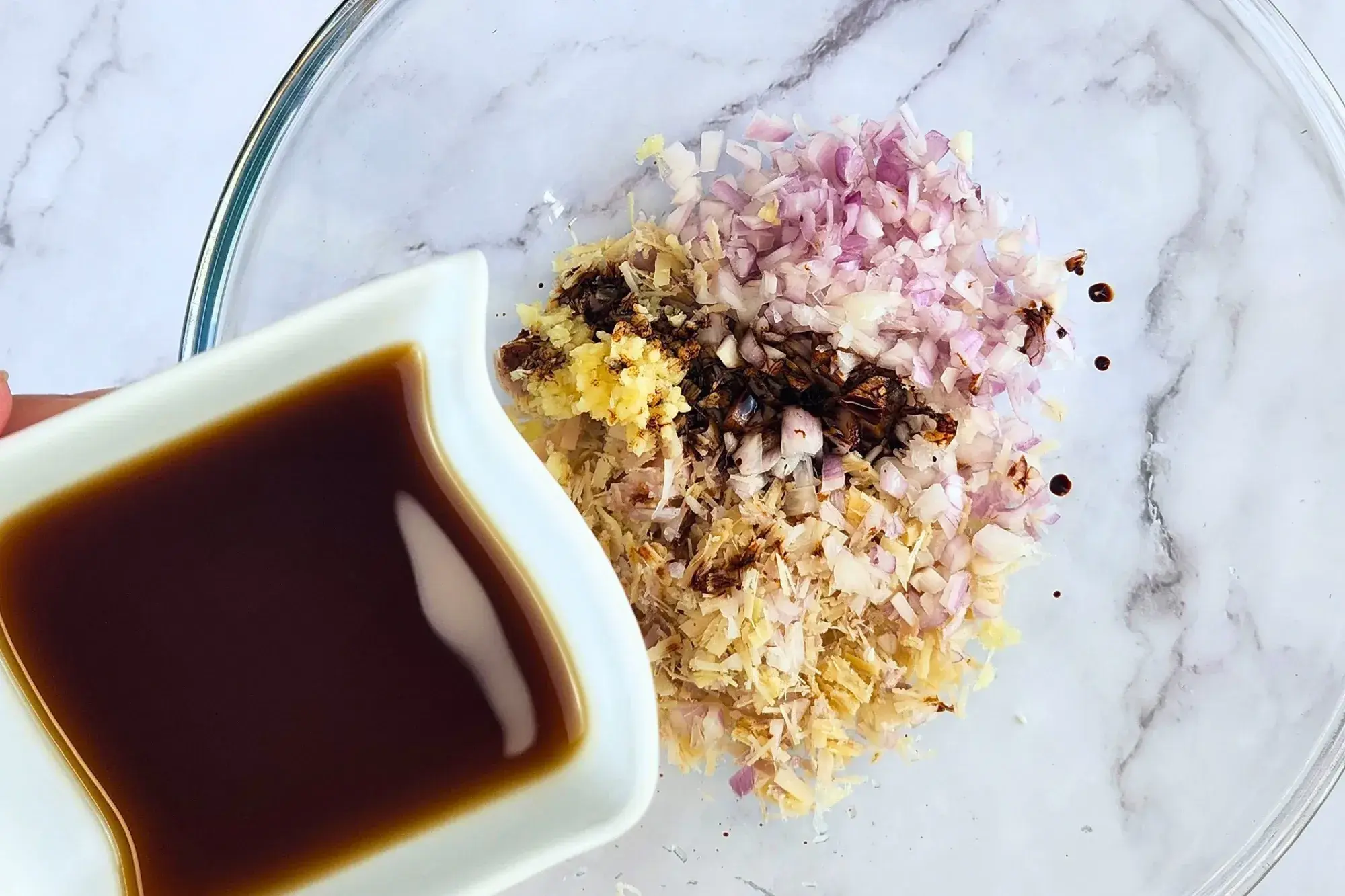 A bowl of fish sauce above a mixing bowl