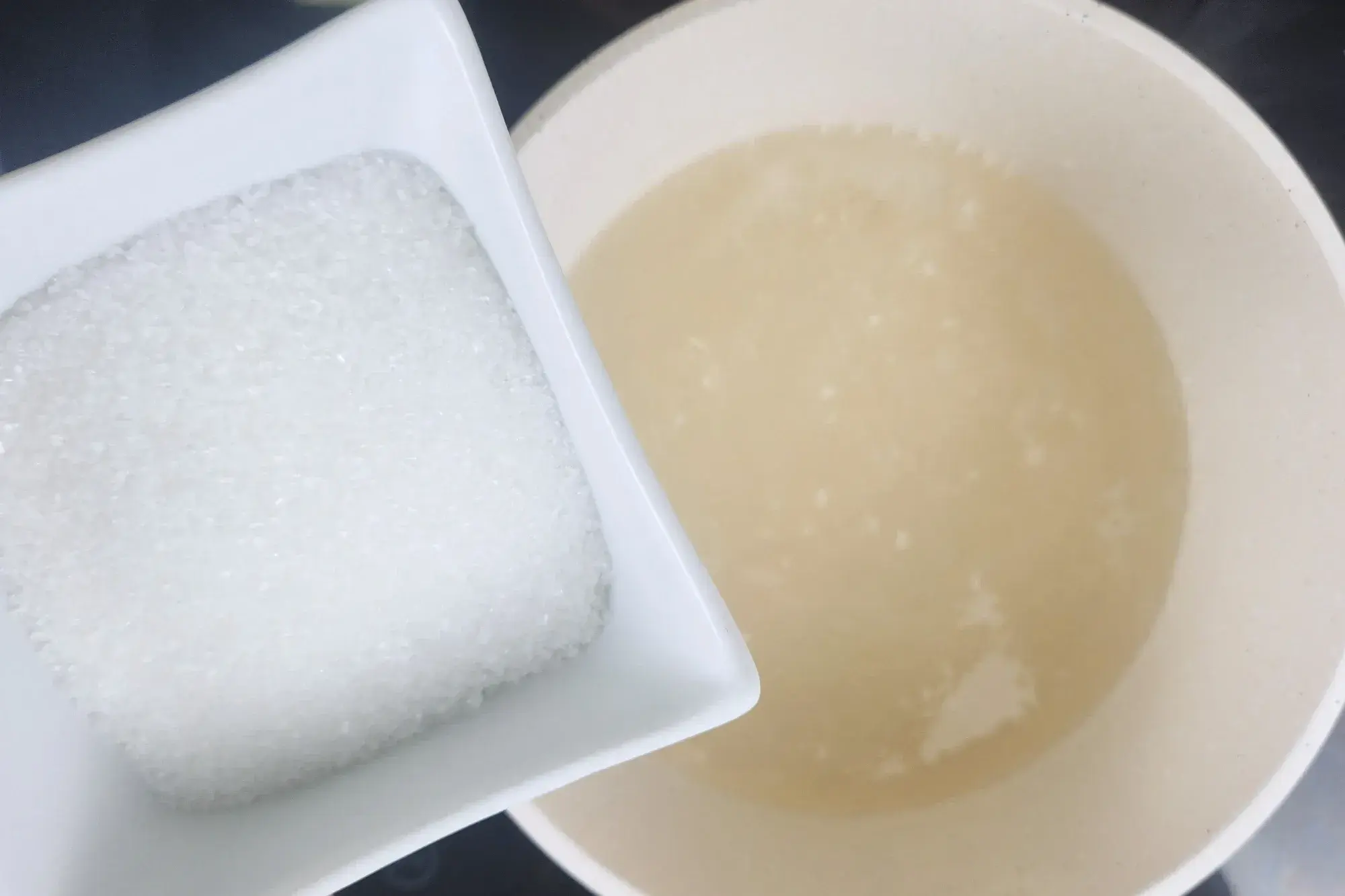 A hand is holding a spatula stir the pot of water