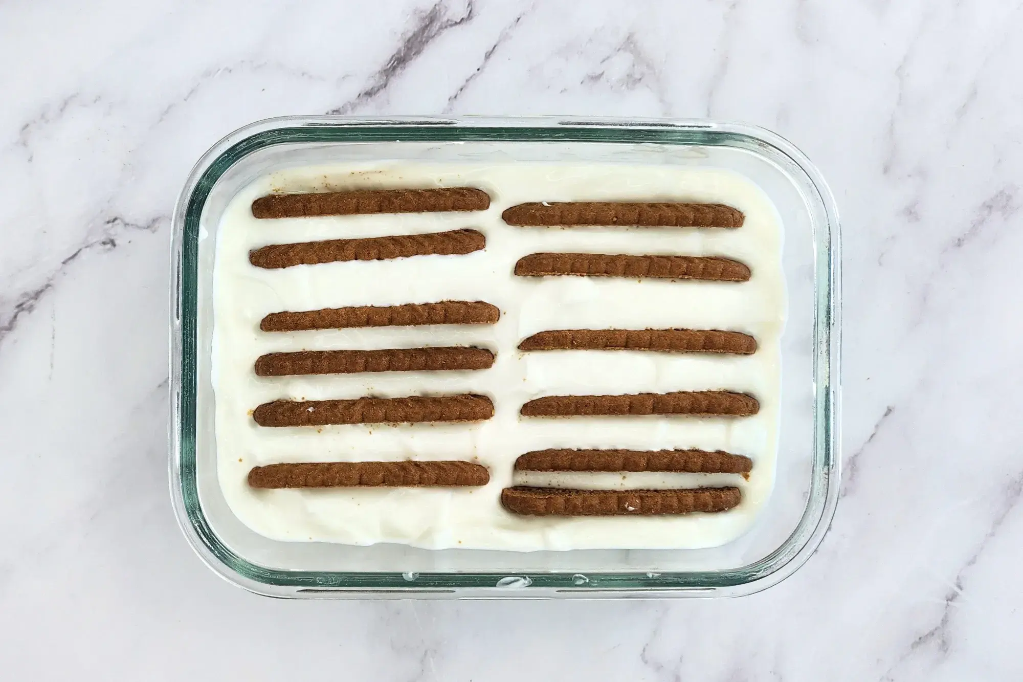 A bowl of yogurt with some cookies.