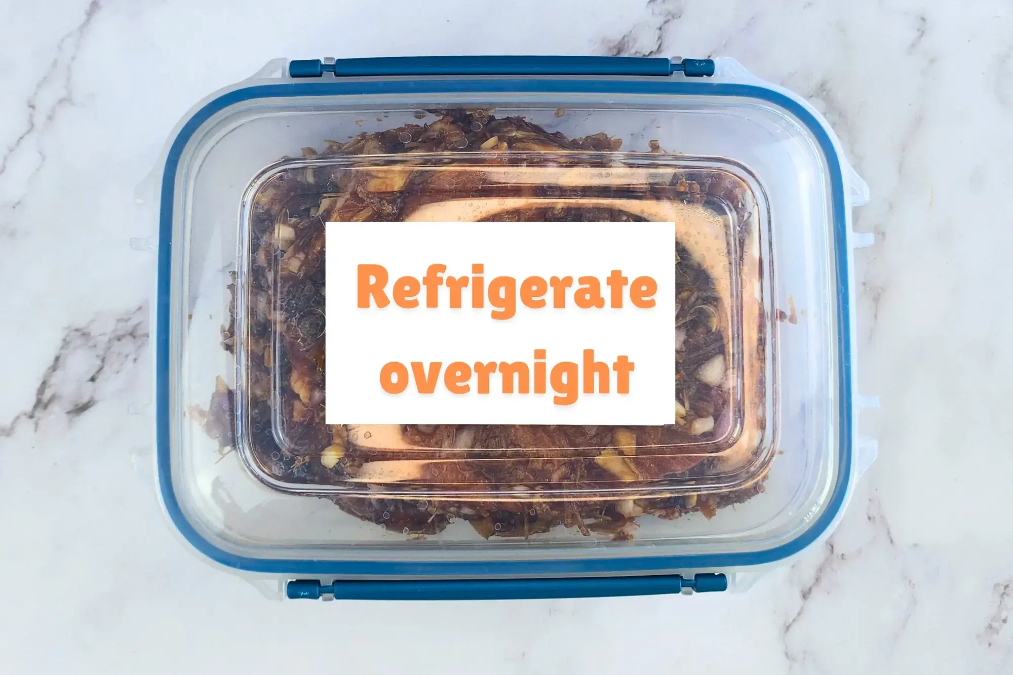 A box of marinated pork chop with a sign on it 'Refrigerate overnight'