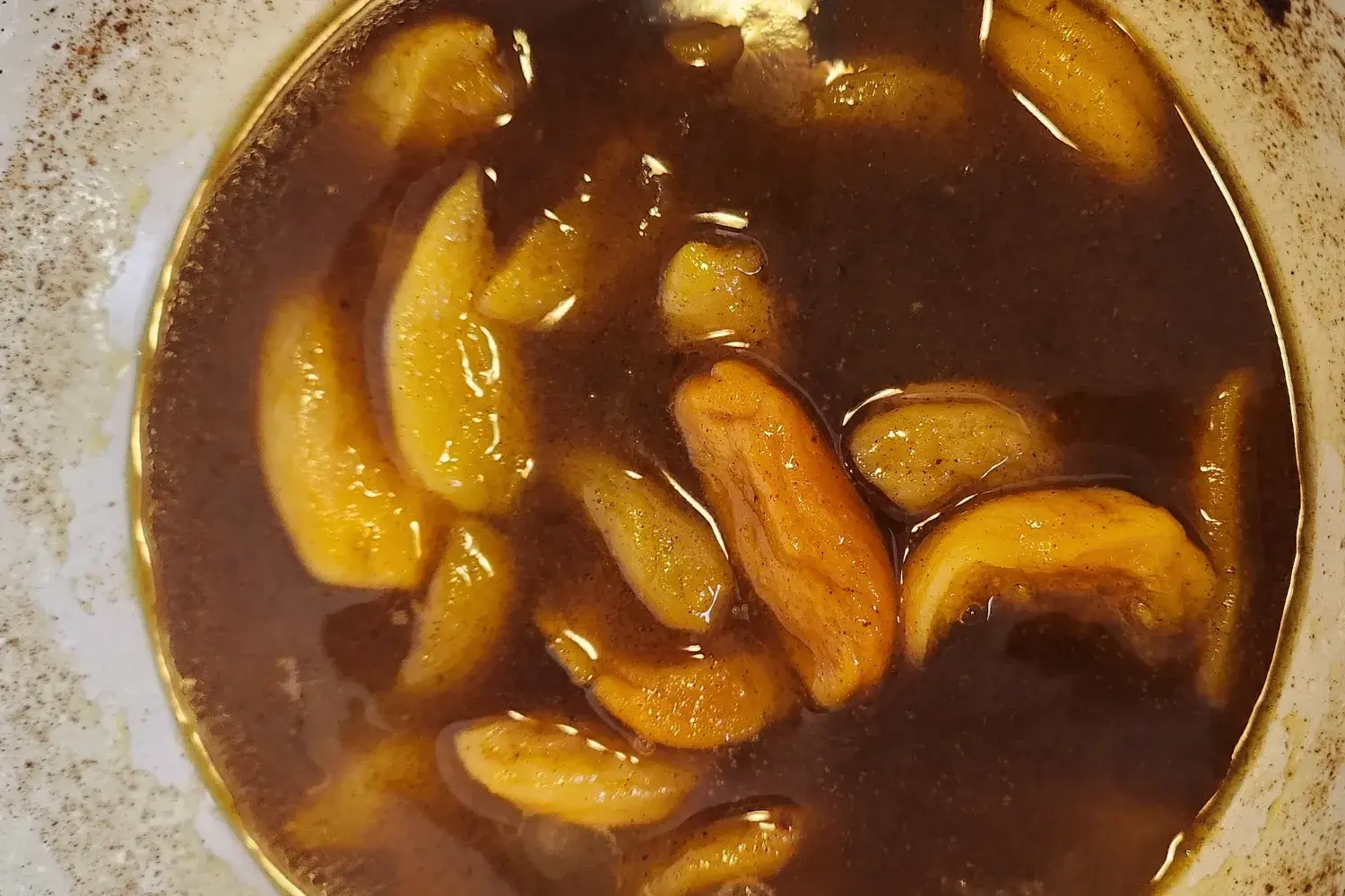 A cooked apricots in a pot.