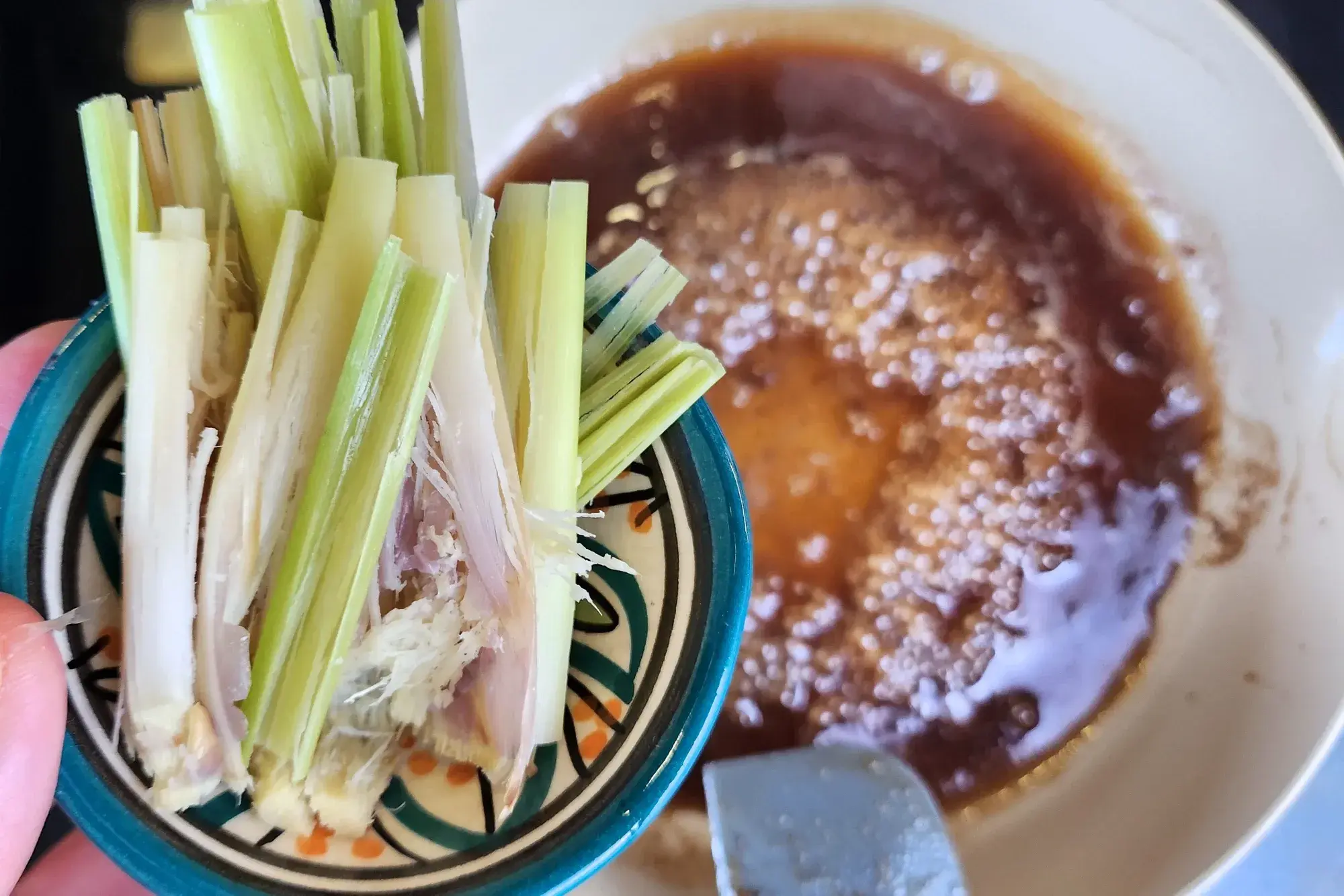 A hand holding a bowl of mashed lemongrass