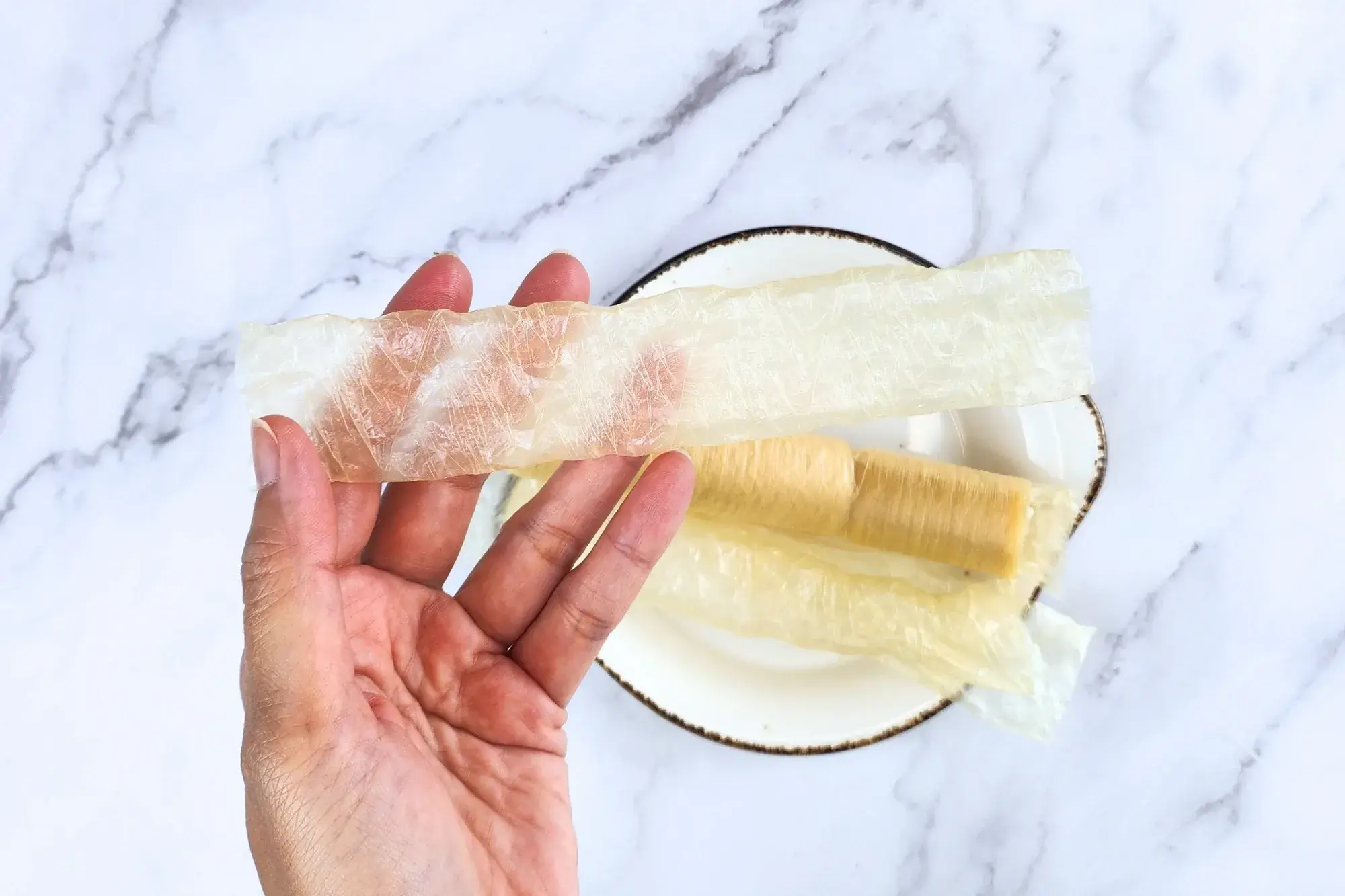 A hand holding sausage casing