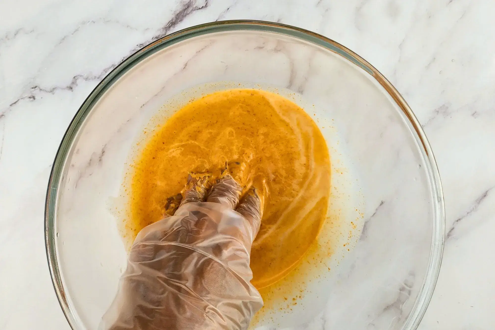 A hand is mixing ingredients in a mixing bowl