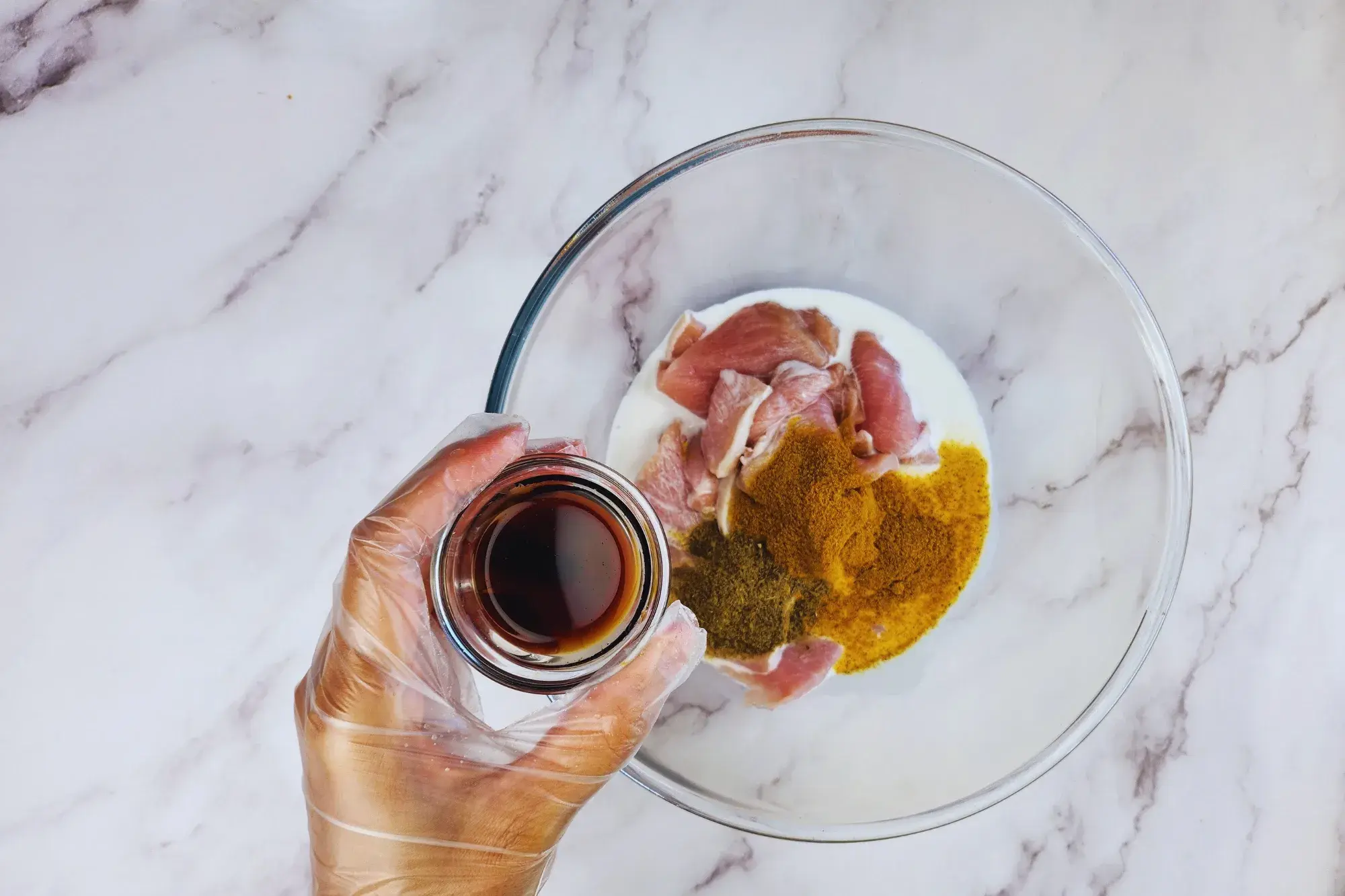 A mixing bowl and a hand holding of bowl of light soy sauce