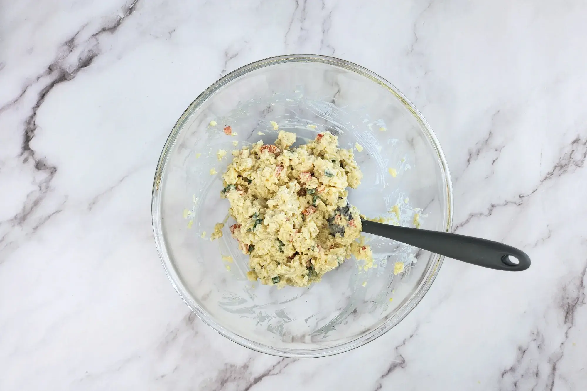 A mixing bowl with mixed heart of palm and seasoning.