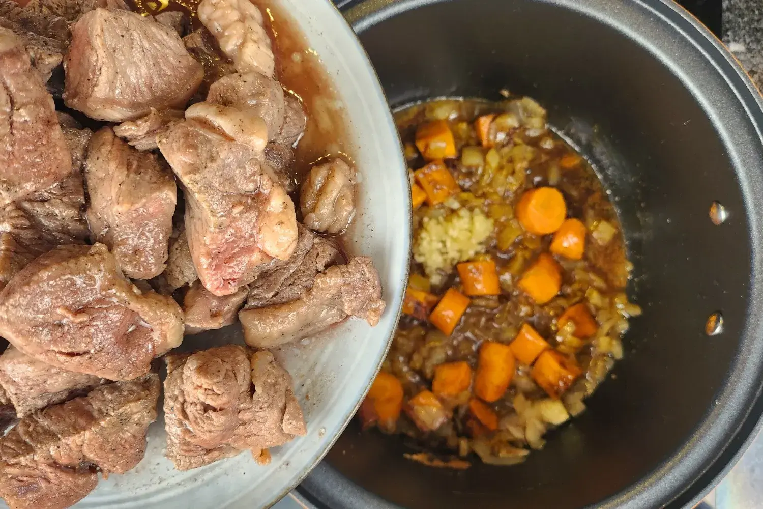 A plate of cooked meat above a cooking pot