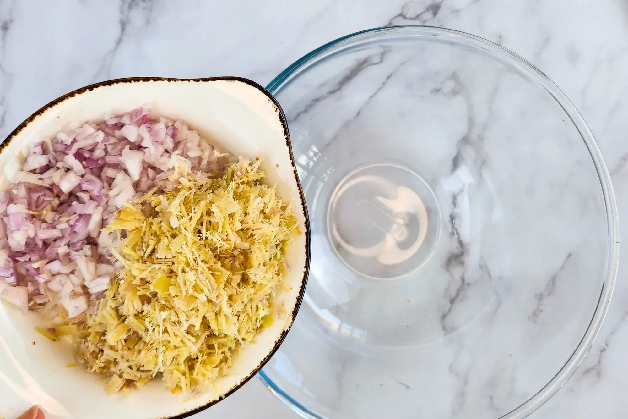 A plate of minced lemongrass and minced shallot above a mixing bowl