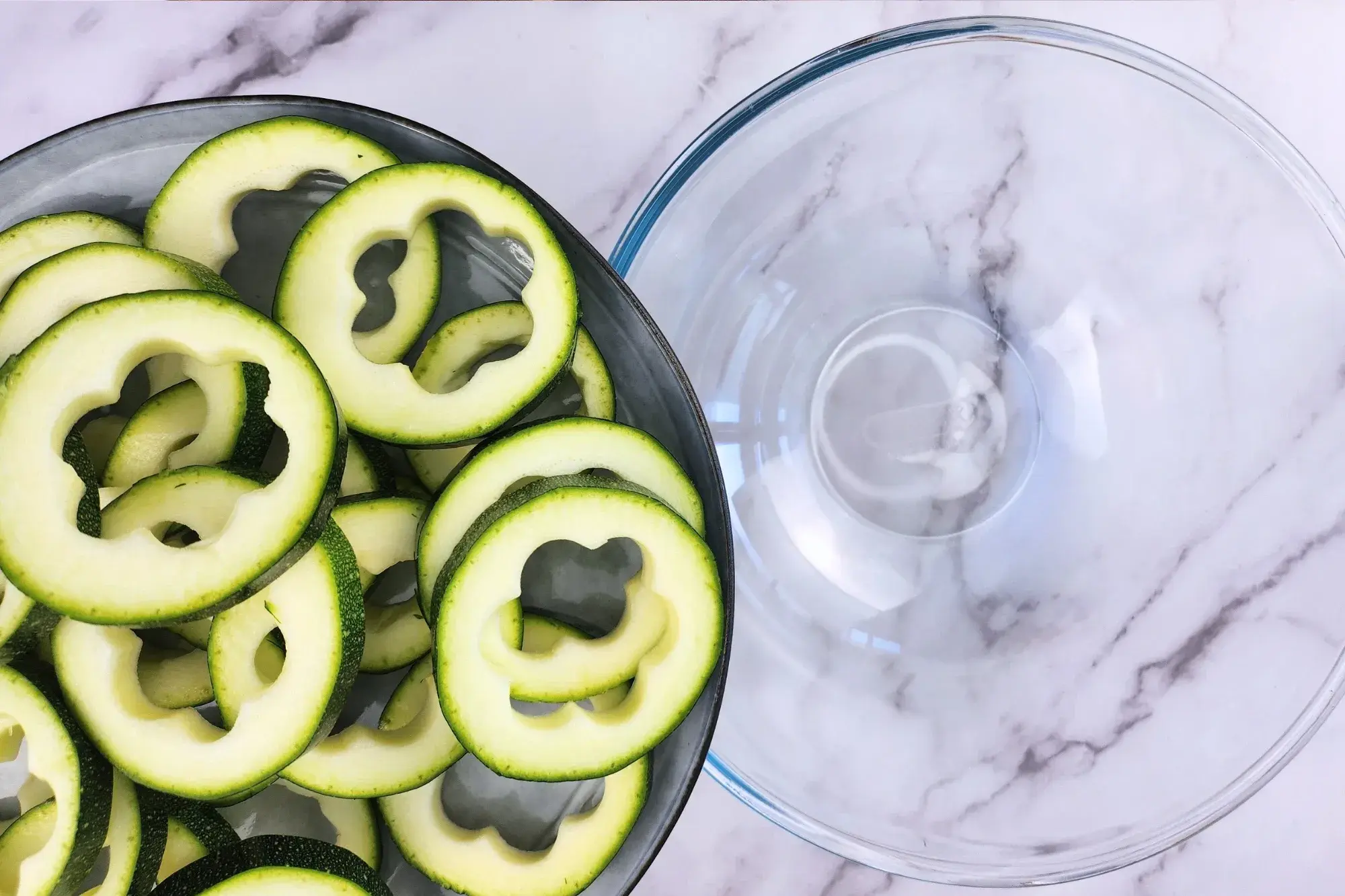 A plate of zucchini rings above a mixing bowl
