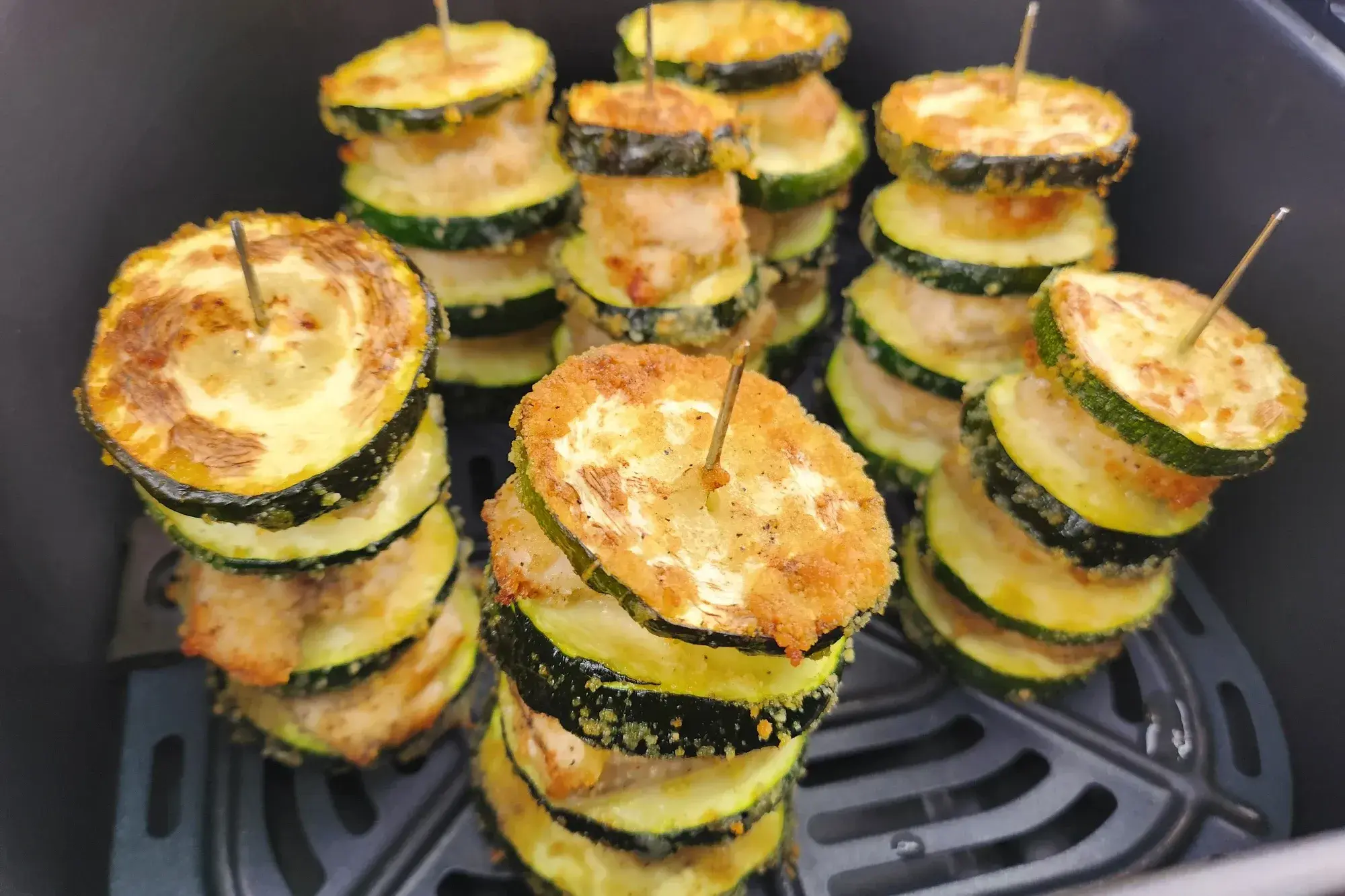 A side of cooked Chicken and Zucchini Skewers in an air fryer basket.