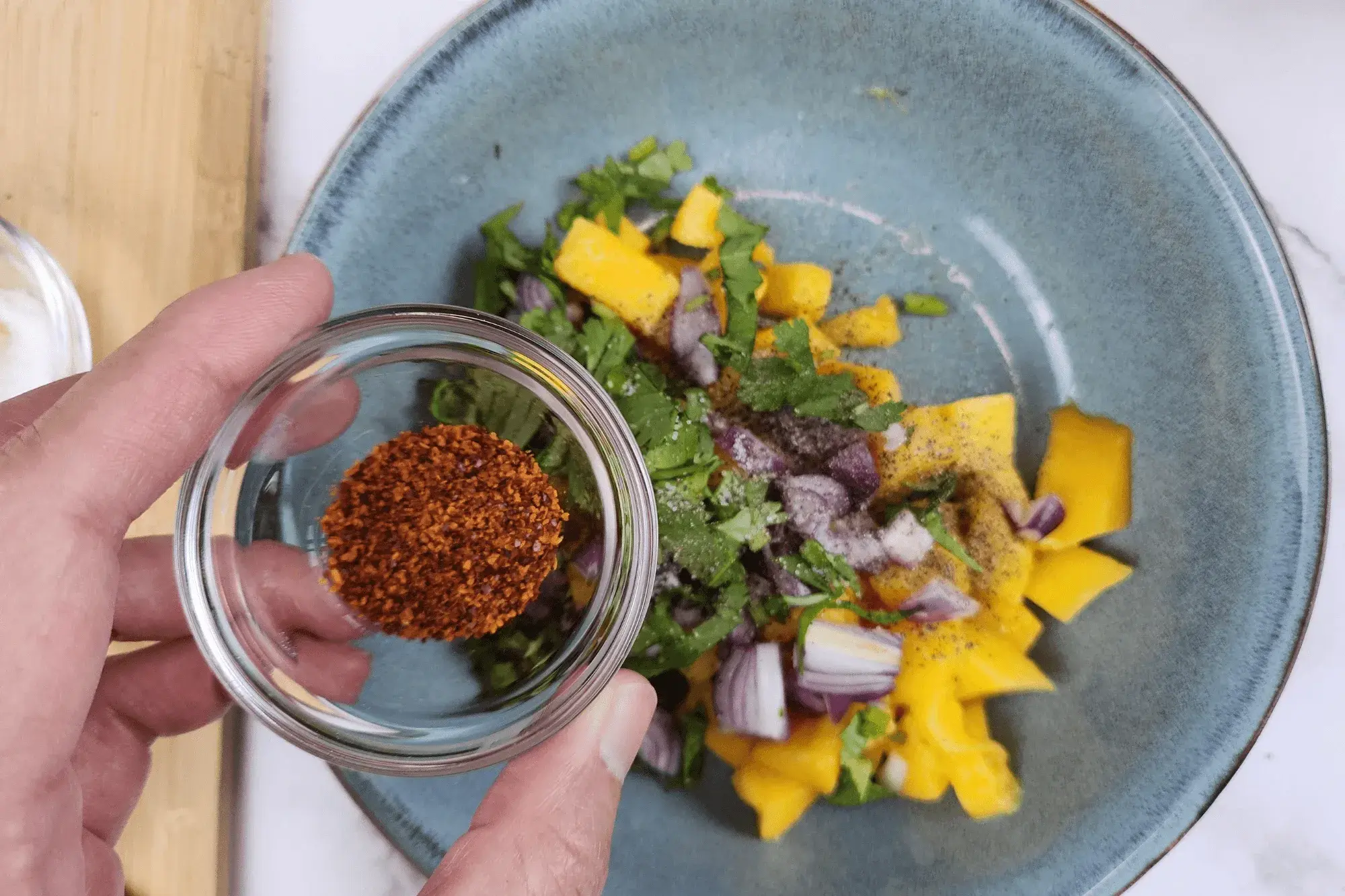 Add chili flakes into mango salad