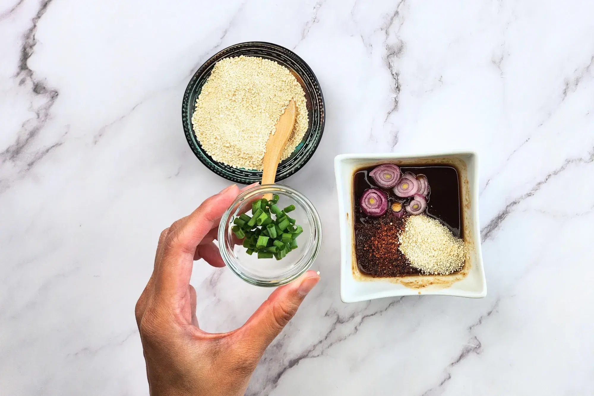 Add chili flakes, toasted rice powder, shallots, and green onions