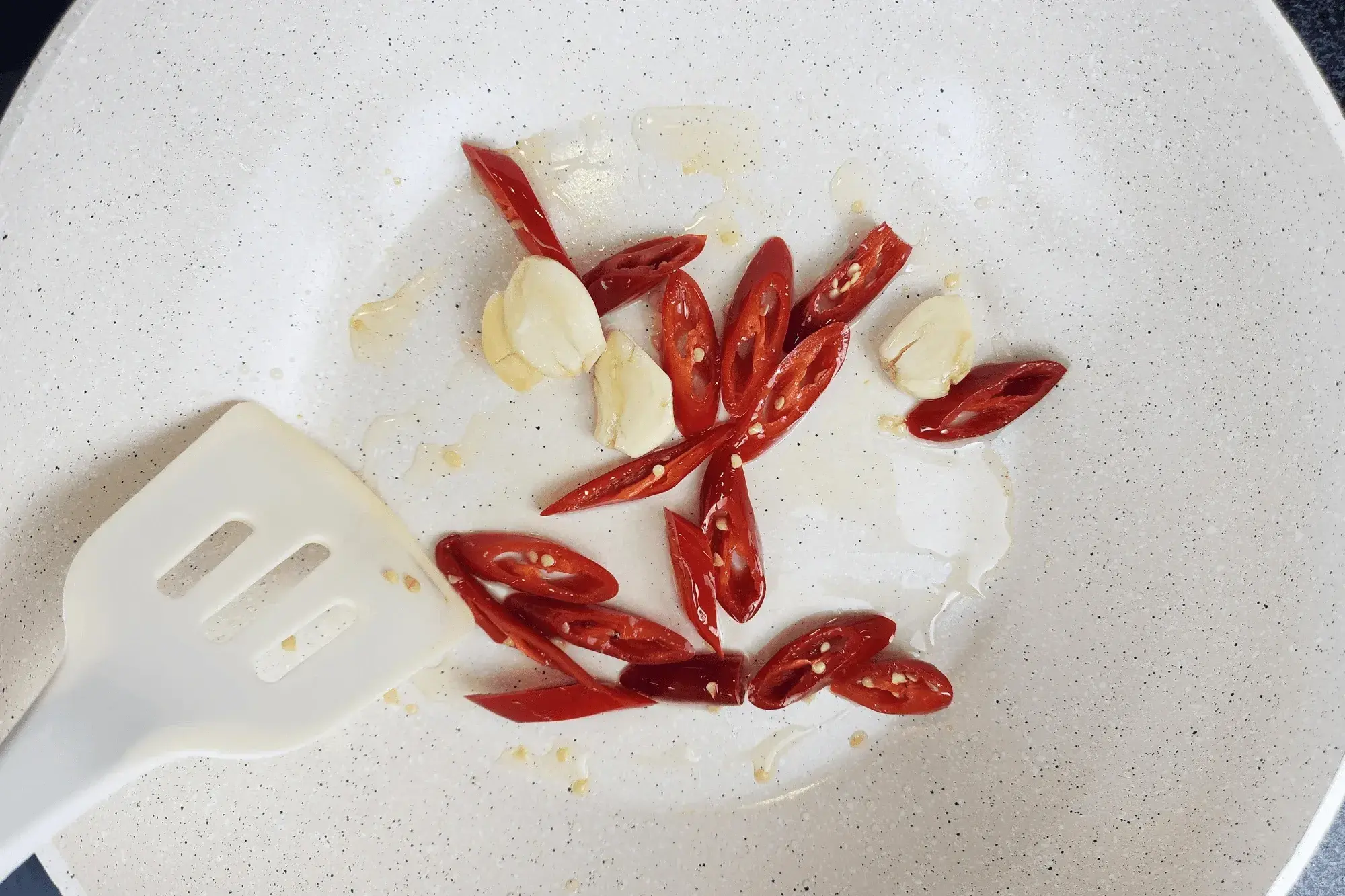 Add garlic and red chilli then stir-fry until fragrant.