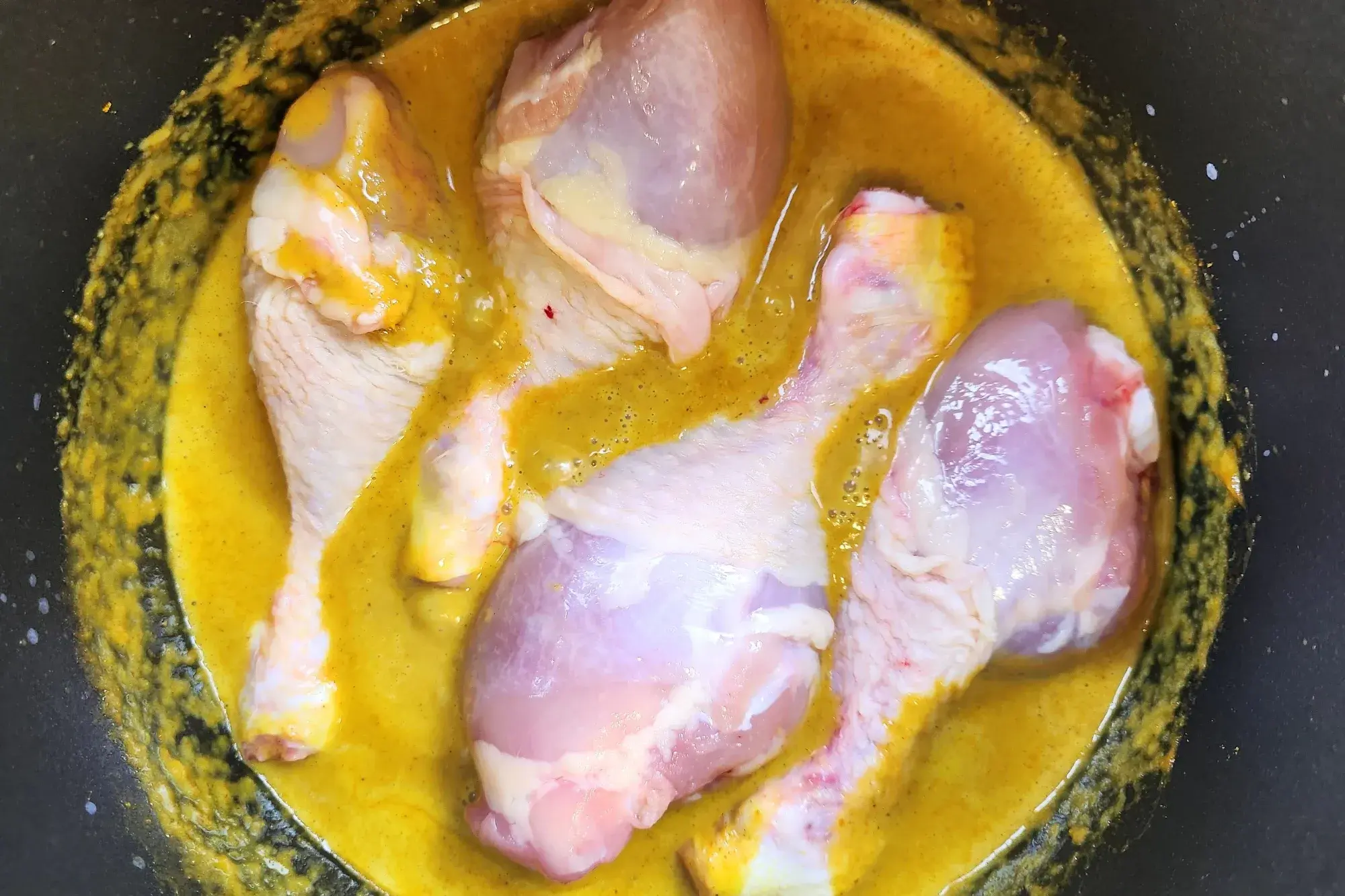 Adding Chicken to curry pot.