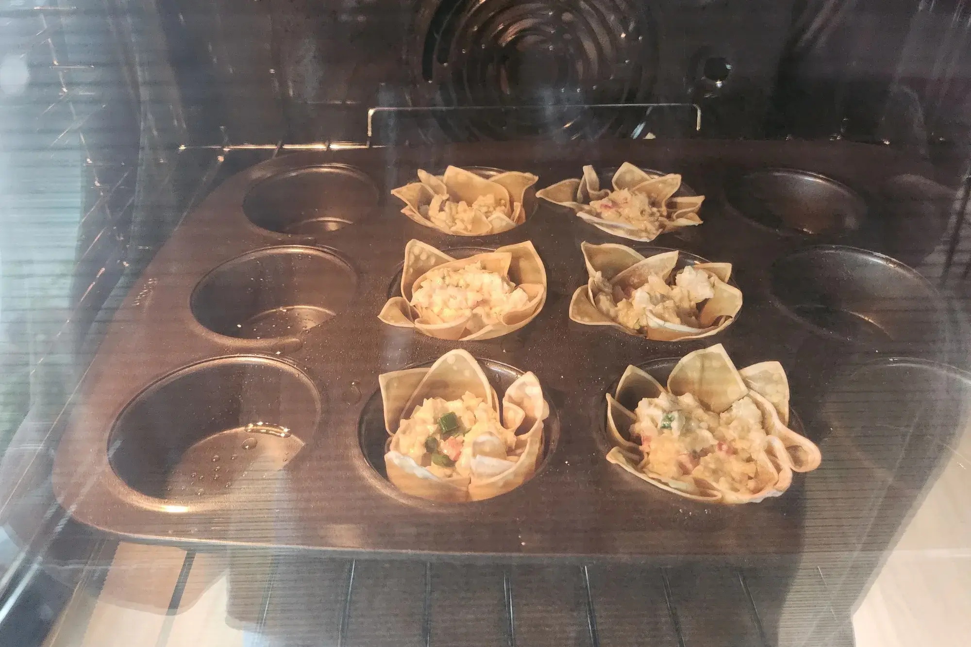 Baking wonton cups with filling in the oven.