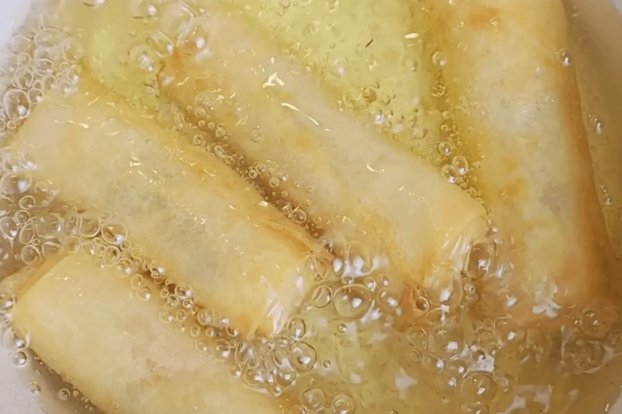 Carefully place the spring rolls in the oil, frying in batches.