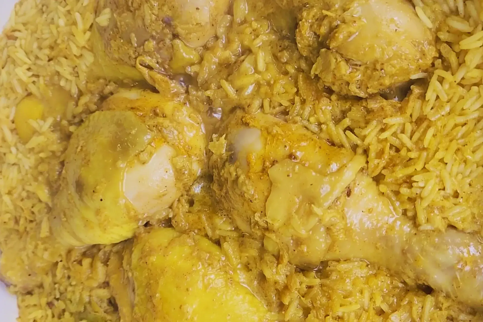 Cooked chicken drumsticks with yellow rice.  