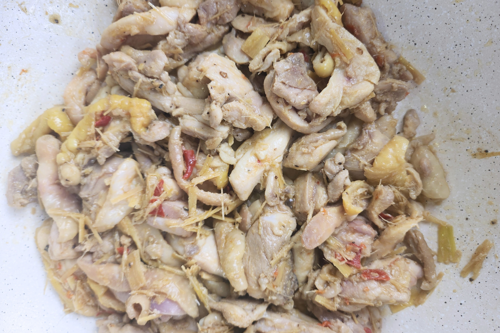 Cooked chicken with lemongrass chili paste in a wok.