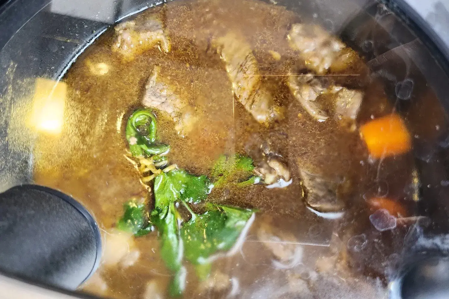 Cooking meat pot with a lid.