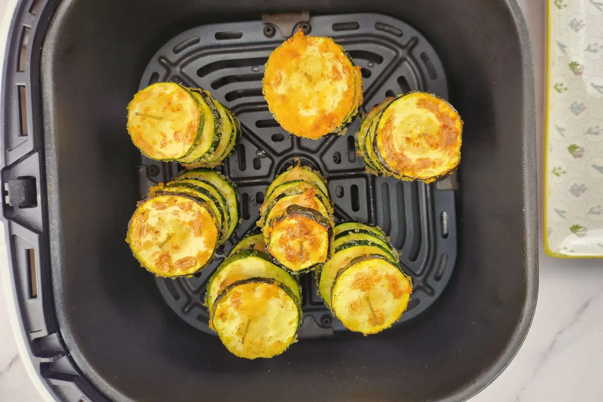 Coooked Chicken and Zucchini Skewers in an air fryer basket.