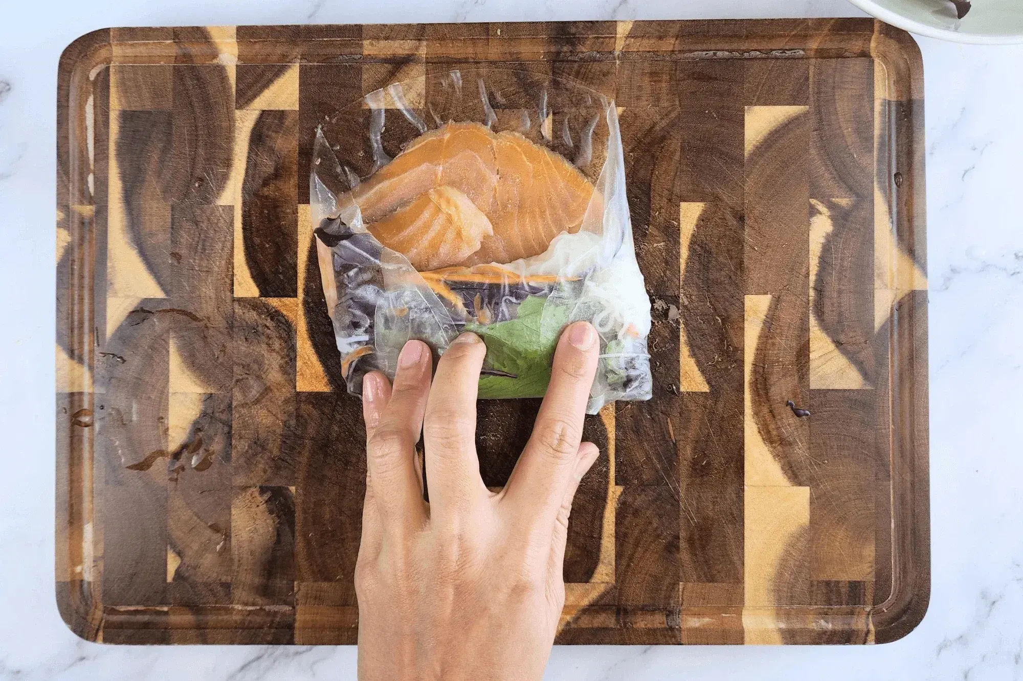 Fold the bottom of the rice paper over the filling with smoked salmon