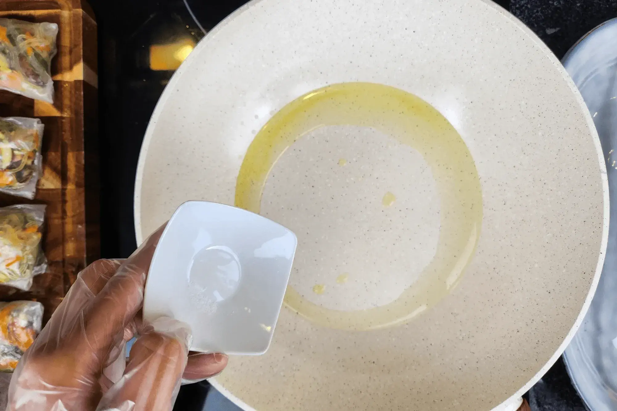 Heat a pan over medium heat, add oil, and sprinkle a pinch of salt.