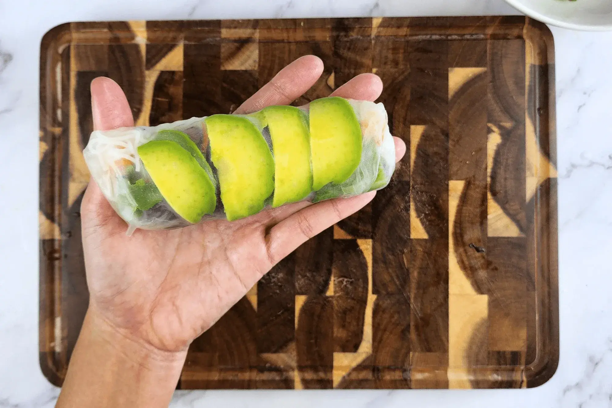 Holding Summer Salad Rolls with Avocado