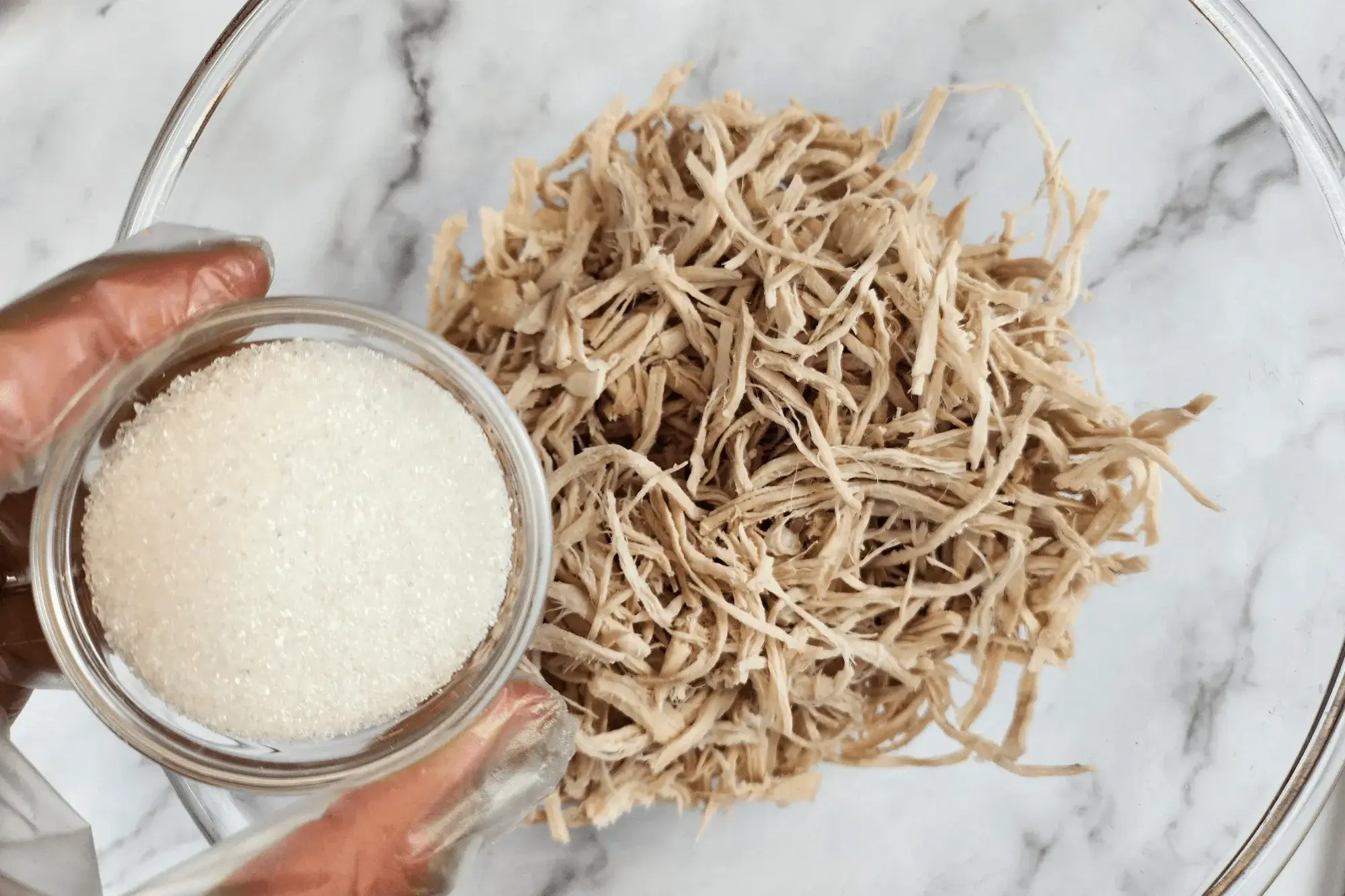 In a bowl, mix the shredded pork with sugar