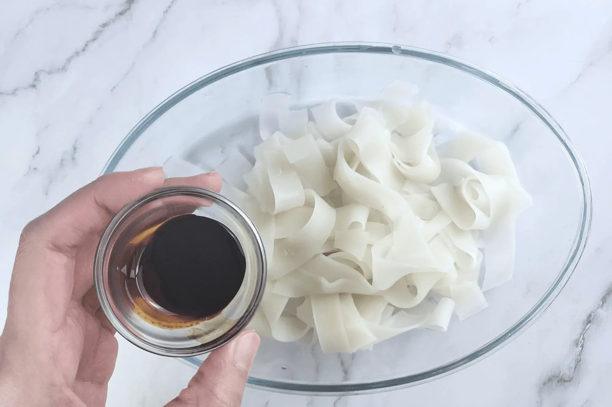 Mix dark soy sauce into the soaked noodles
