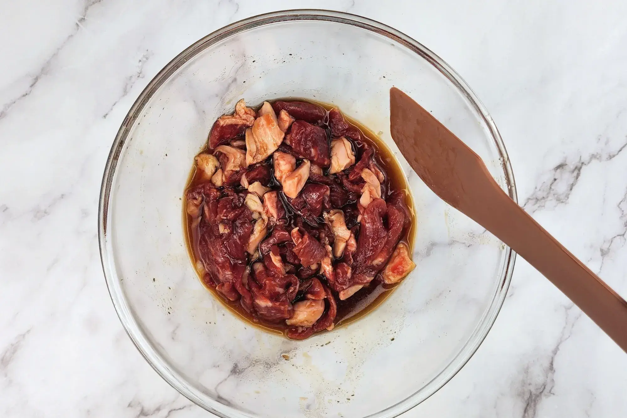 Mixed sliced beef in a mixing bowl.