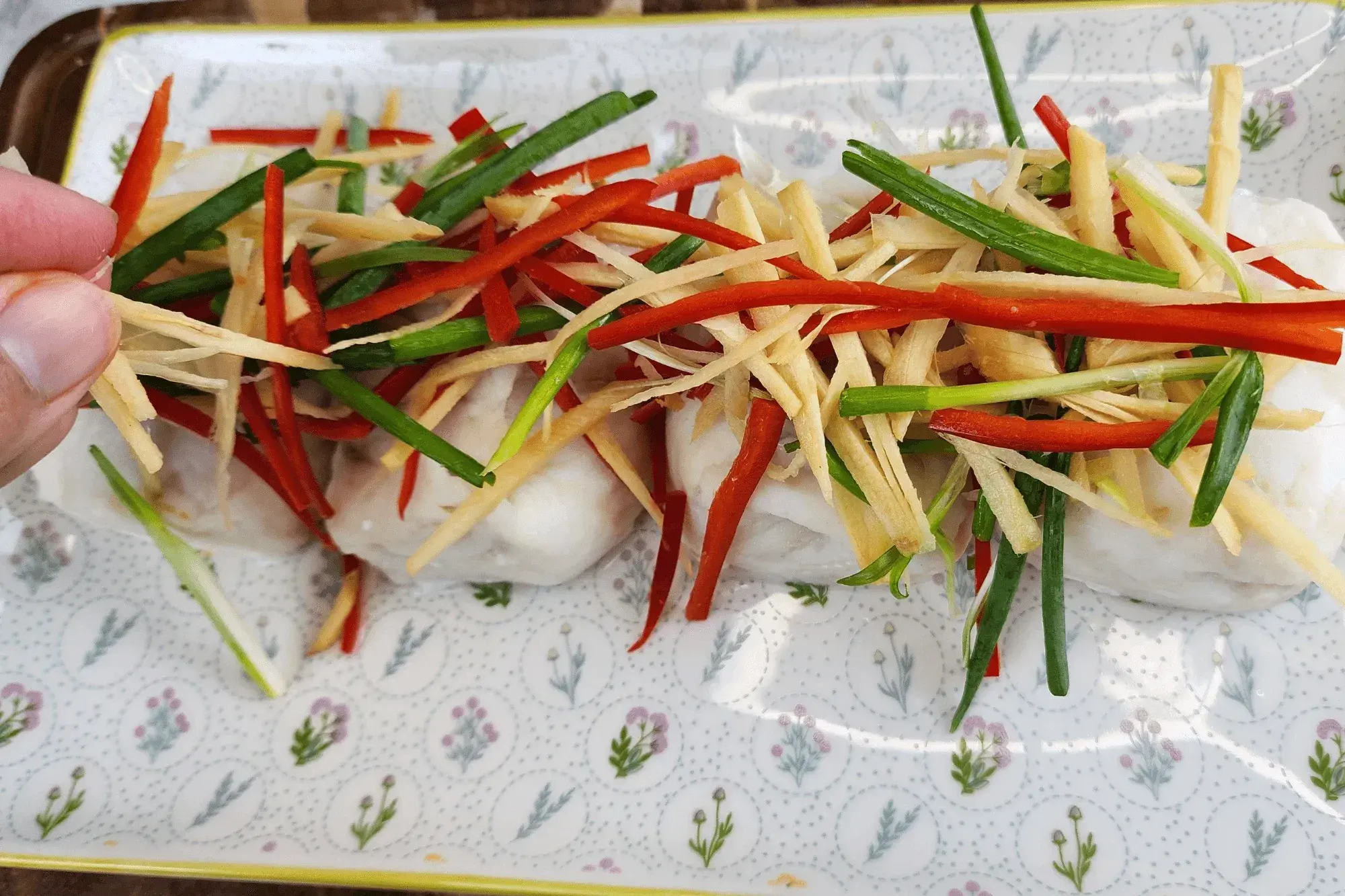 Place the julienned vegetables on top of the steamed fish.
