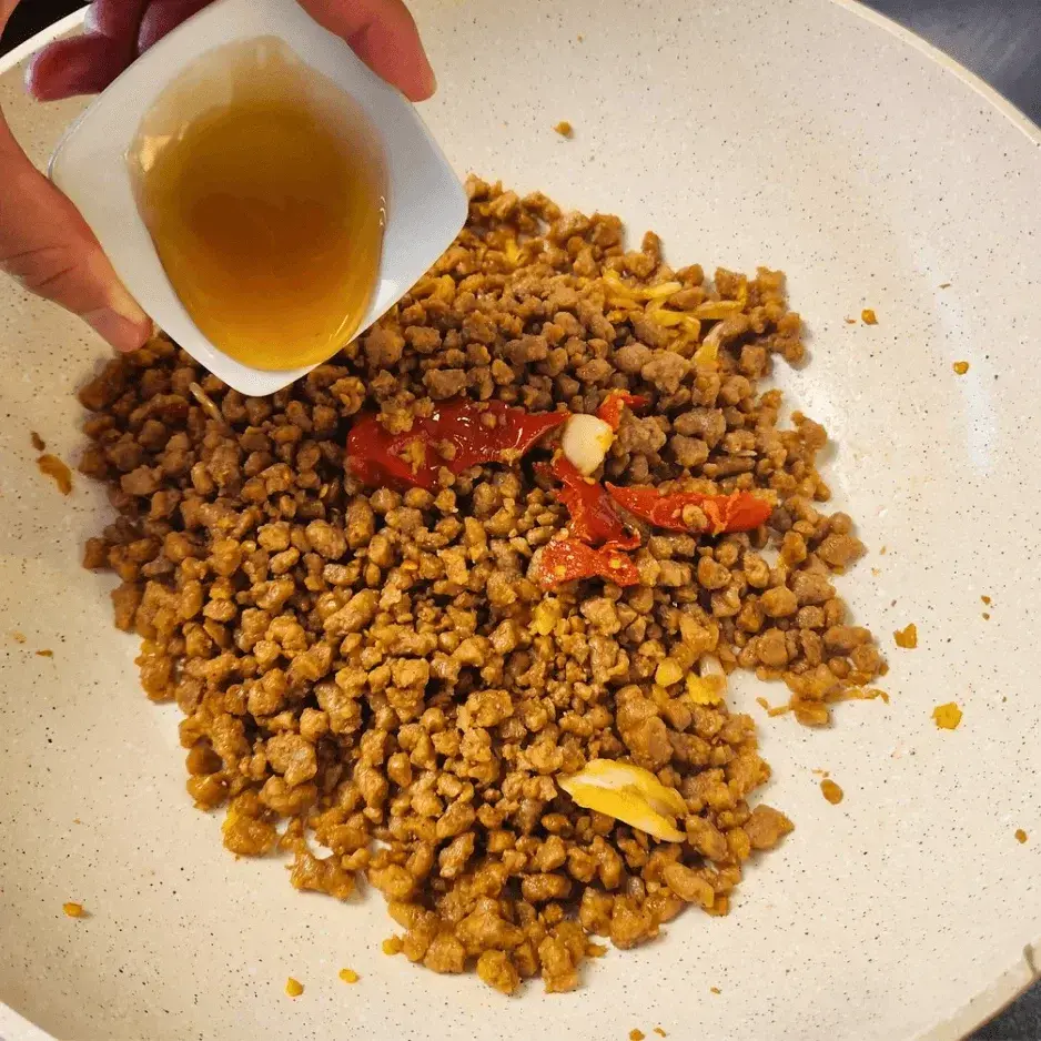Adding mushroom sauce to the pan