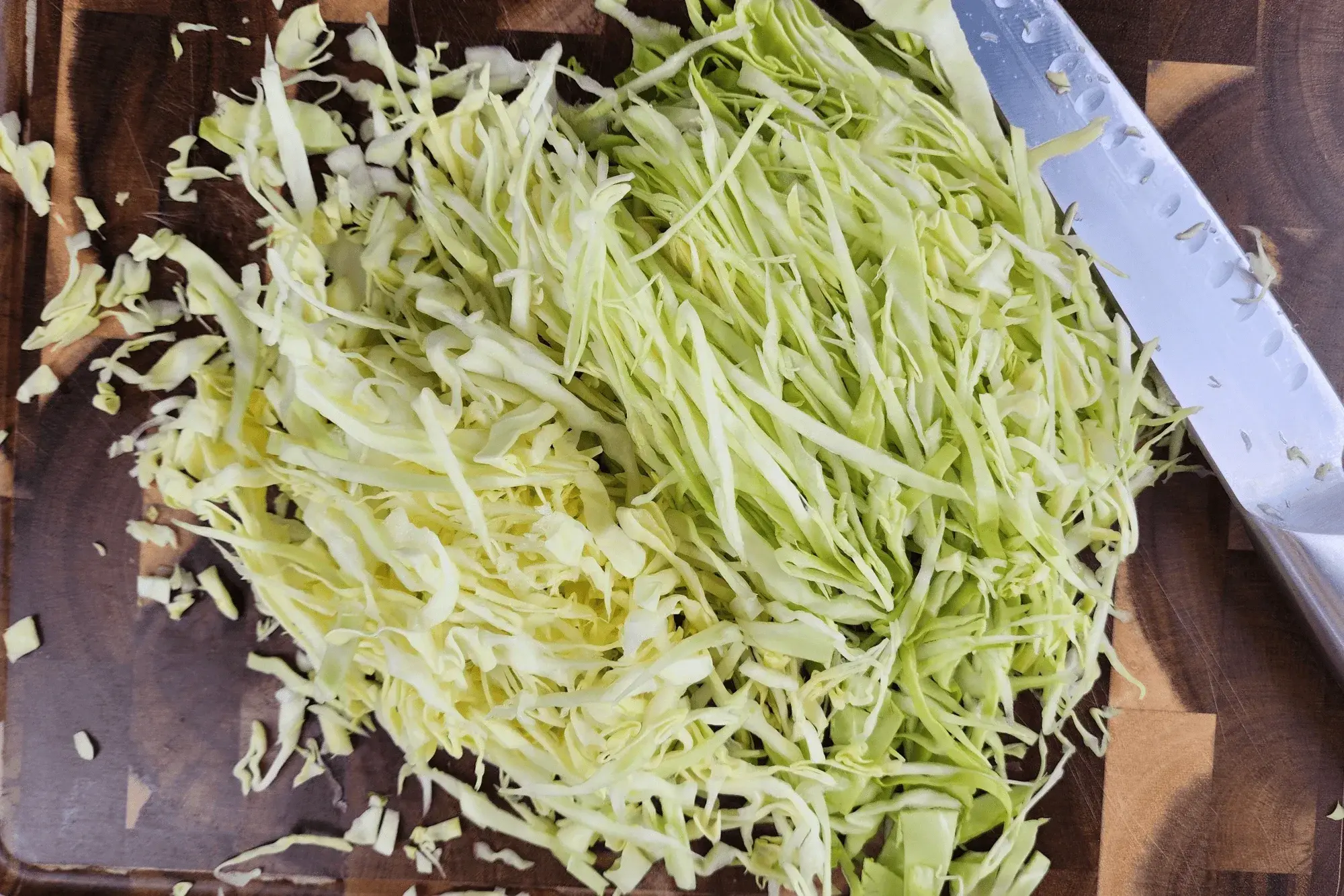 Shred the cabbage into thin strips.