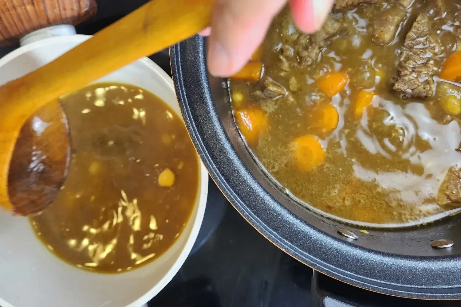 Two pots with cooking meat and a pot with broth.