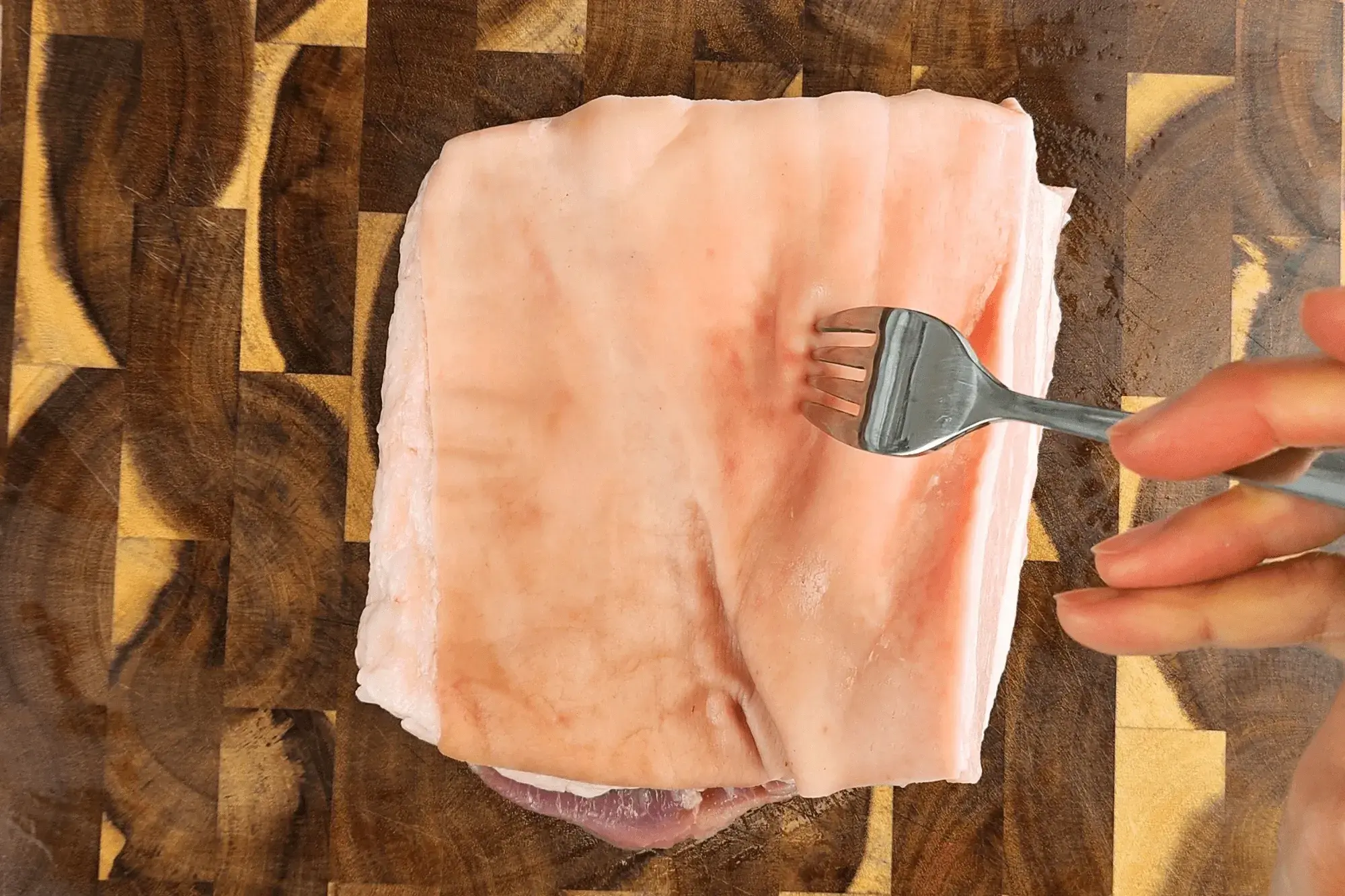 Use a knife or fork to poke holes all over the pork skin.