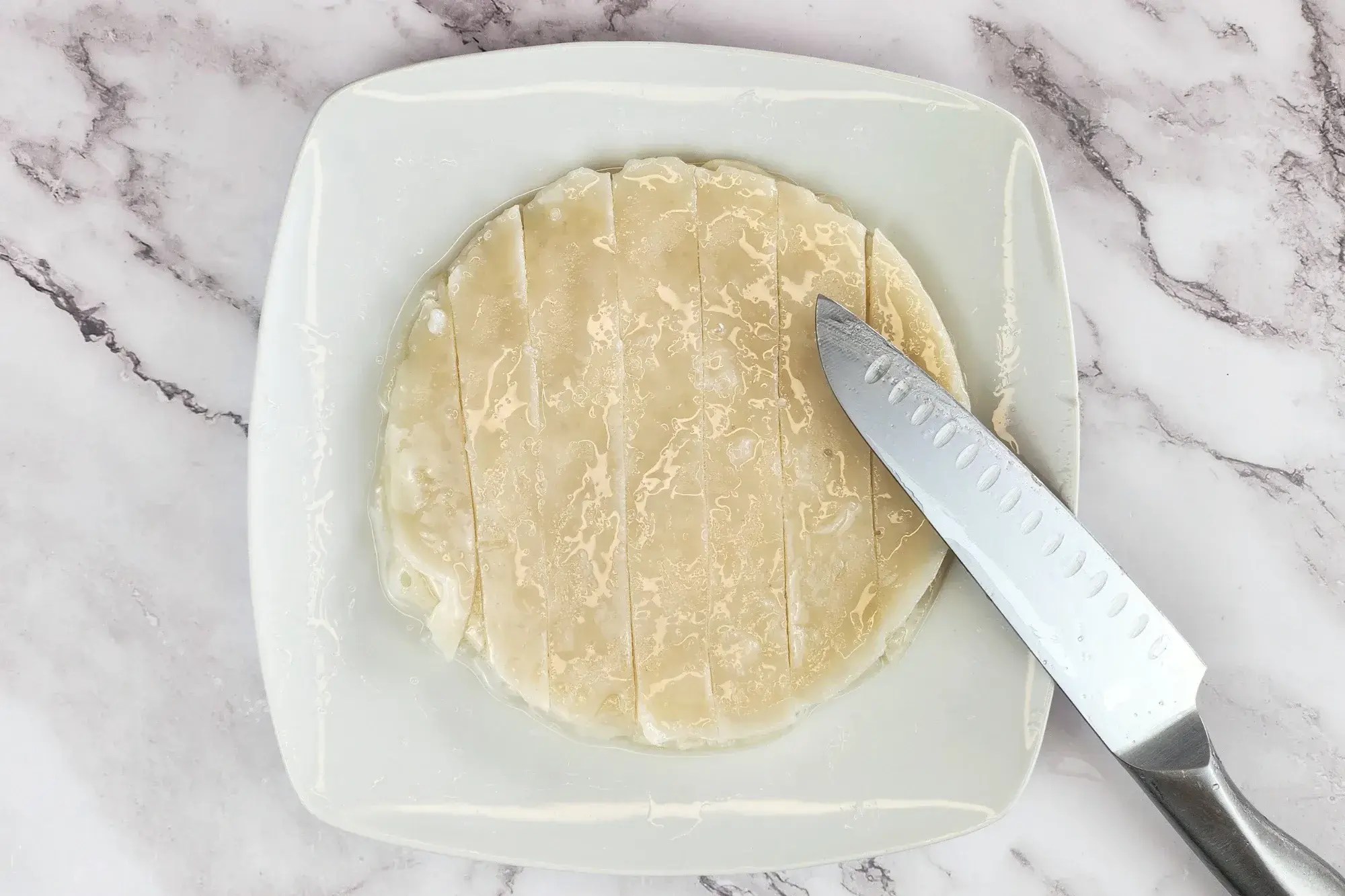 use an oiled knife to cut the noodle sheets into wide strips