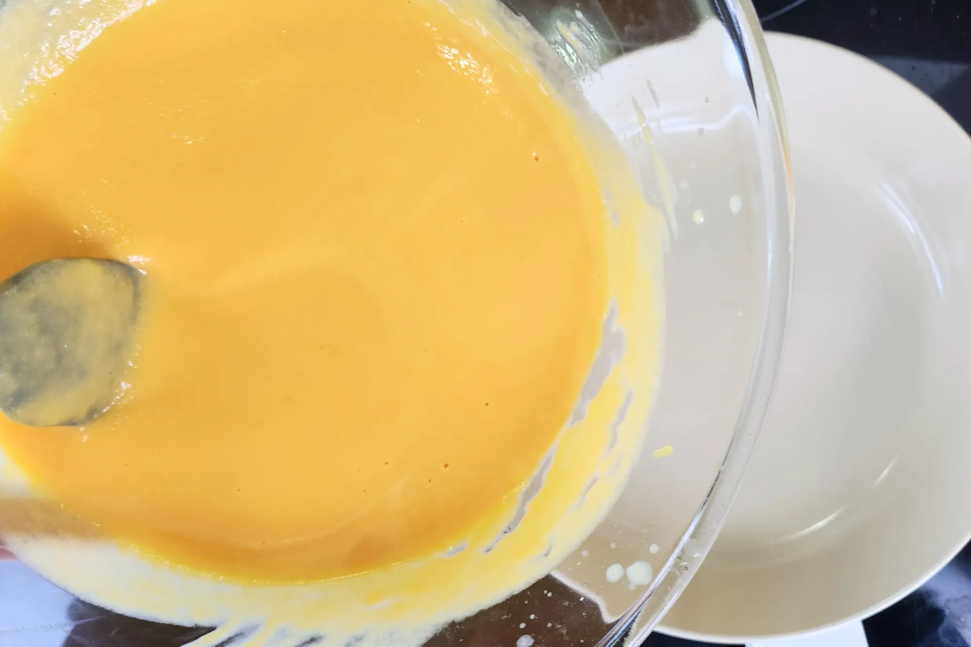 A mixing pumpkin puree is above a pan.