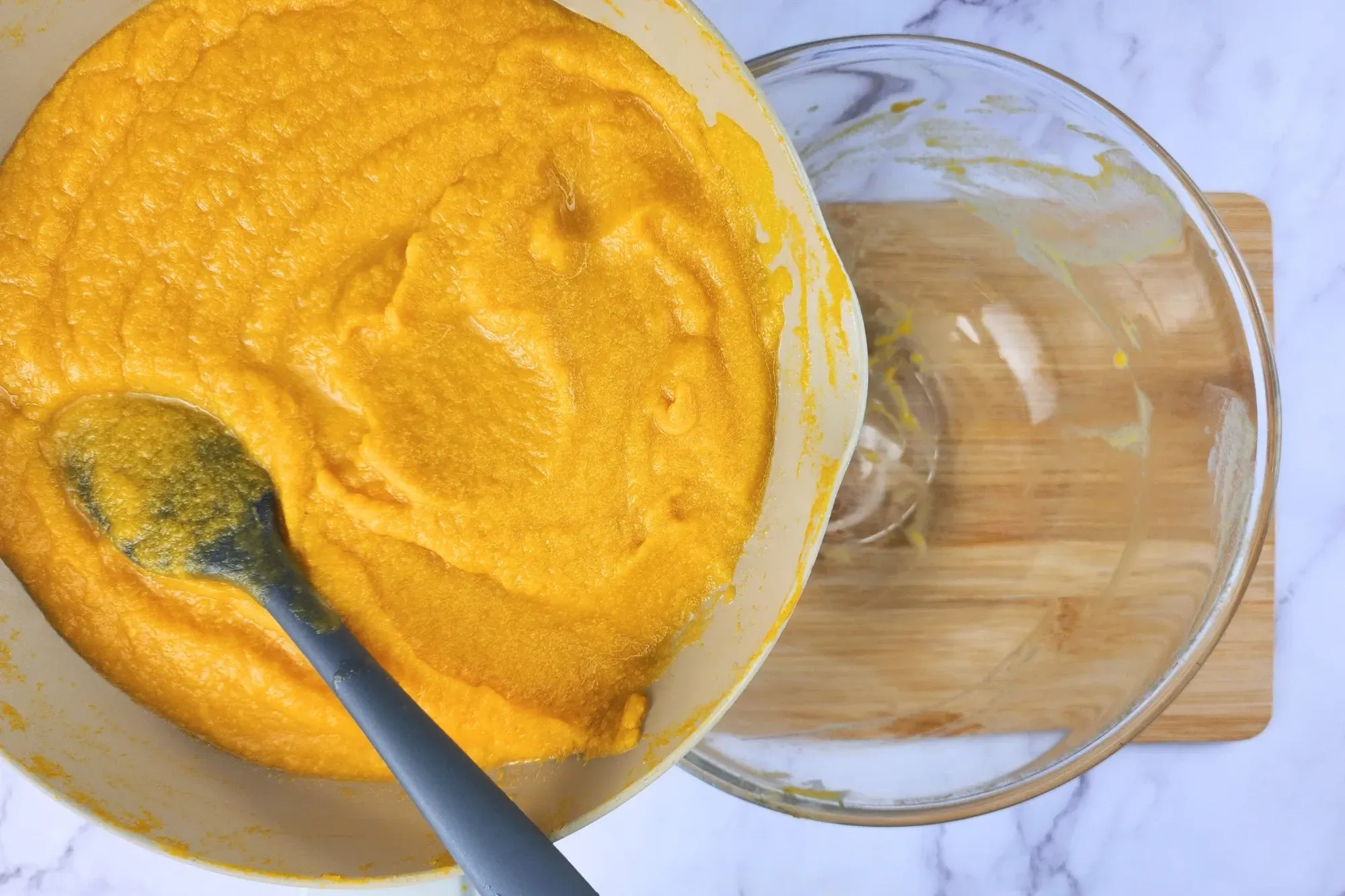 A pan of cooked pumpkin puree above a mixing bowl.