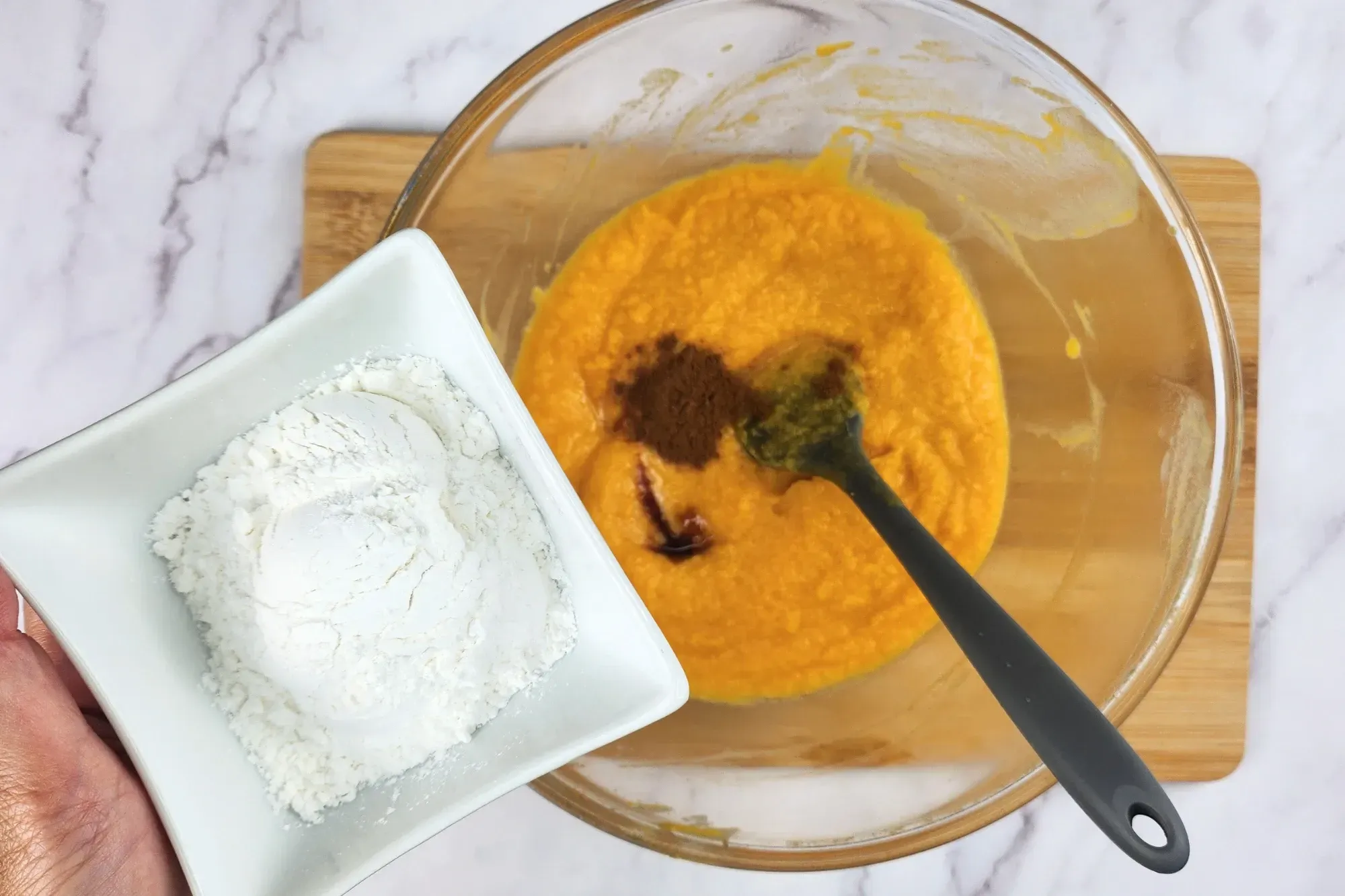 A bowl of flour above a mixing bowl.