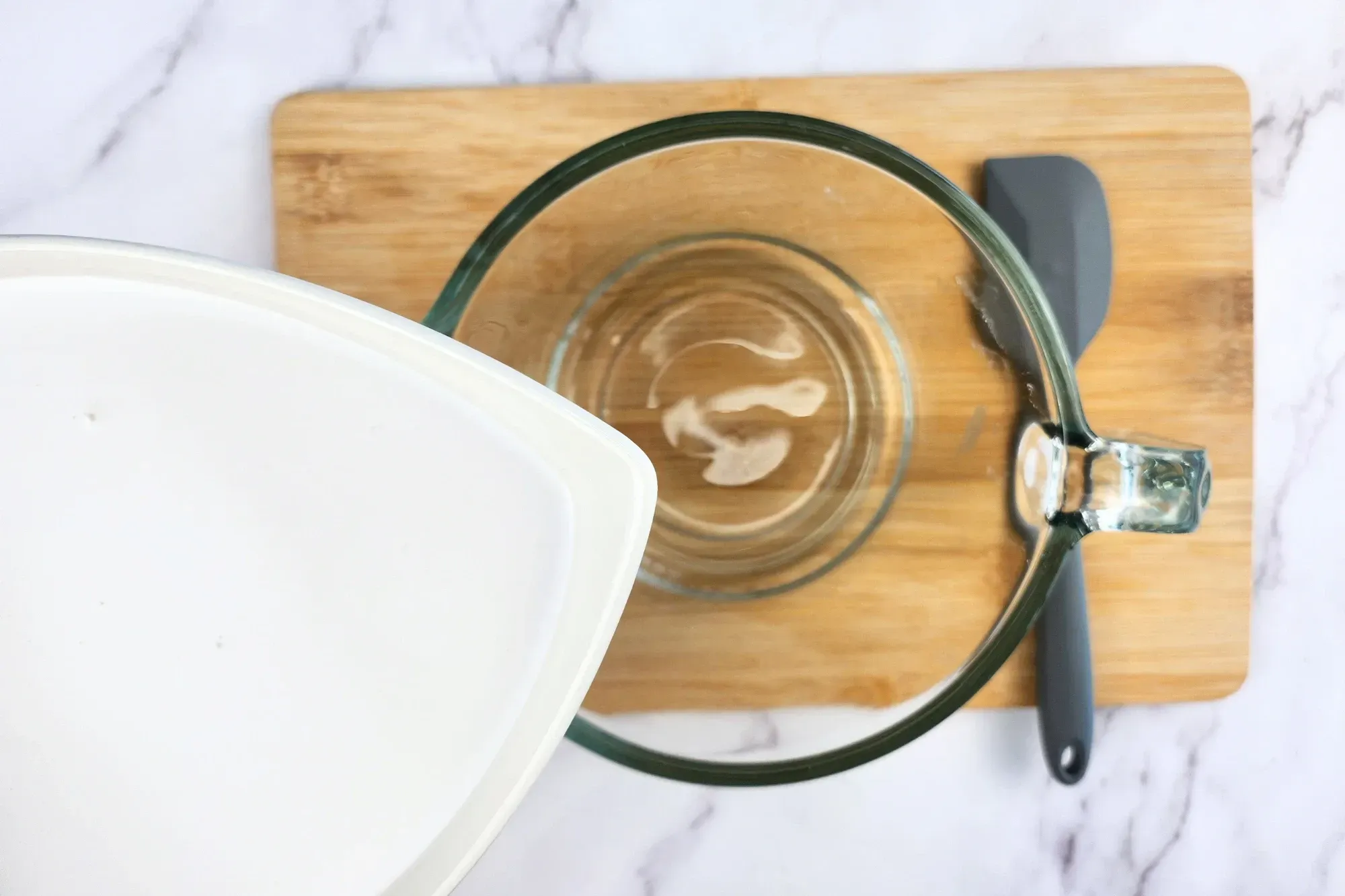 A bowl of coconut milk above a jar.
