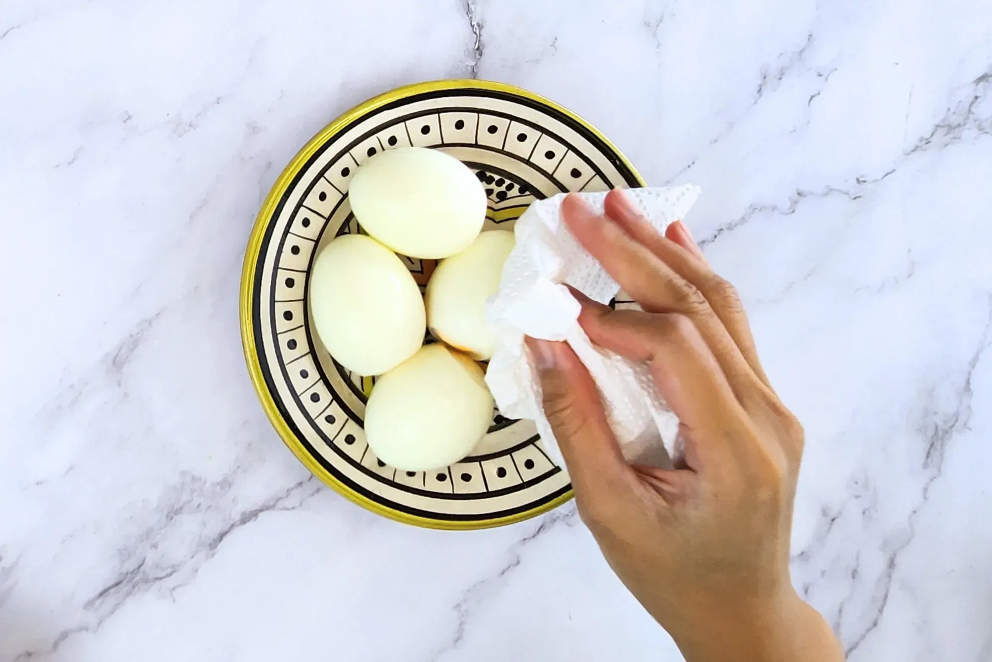 A hand holding paper and dry off hard boiled eggs