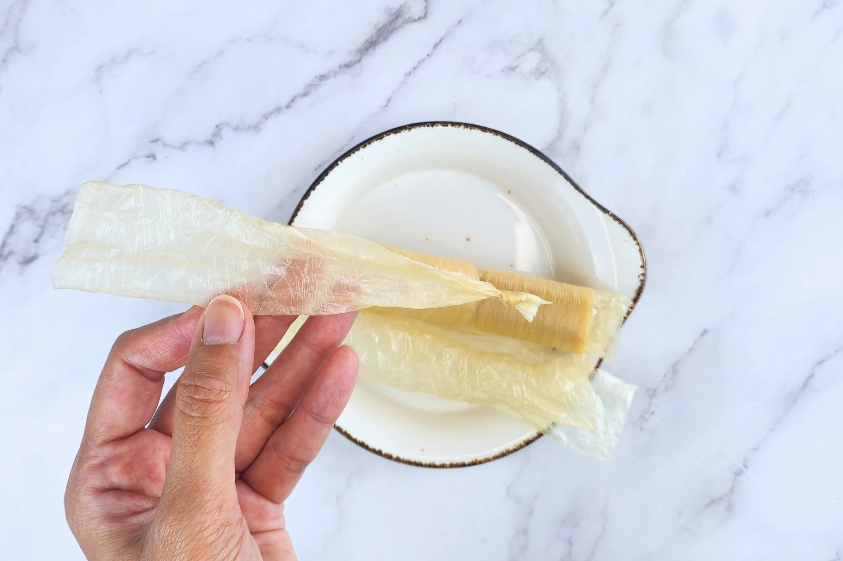 A hand holding tied one end og sausage casing